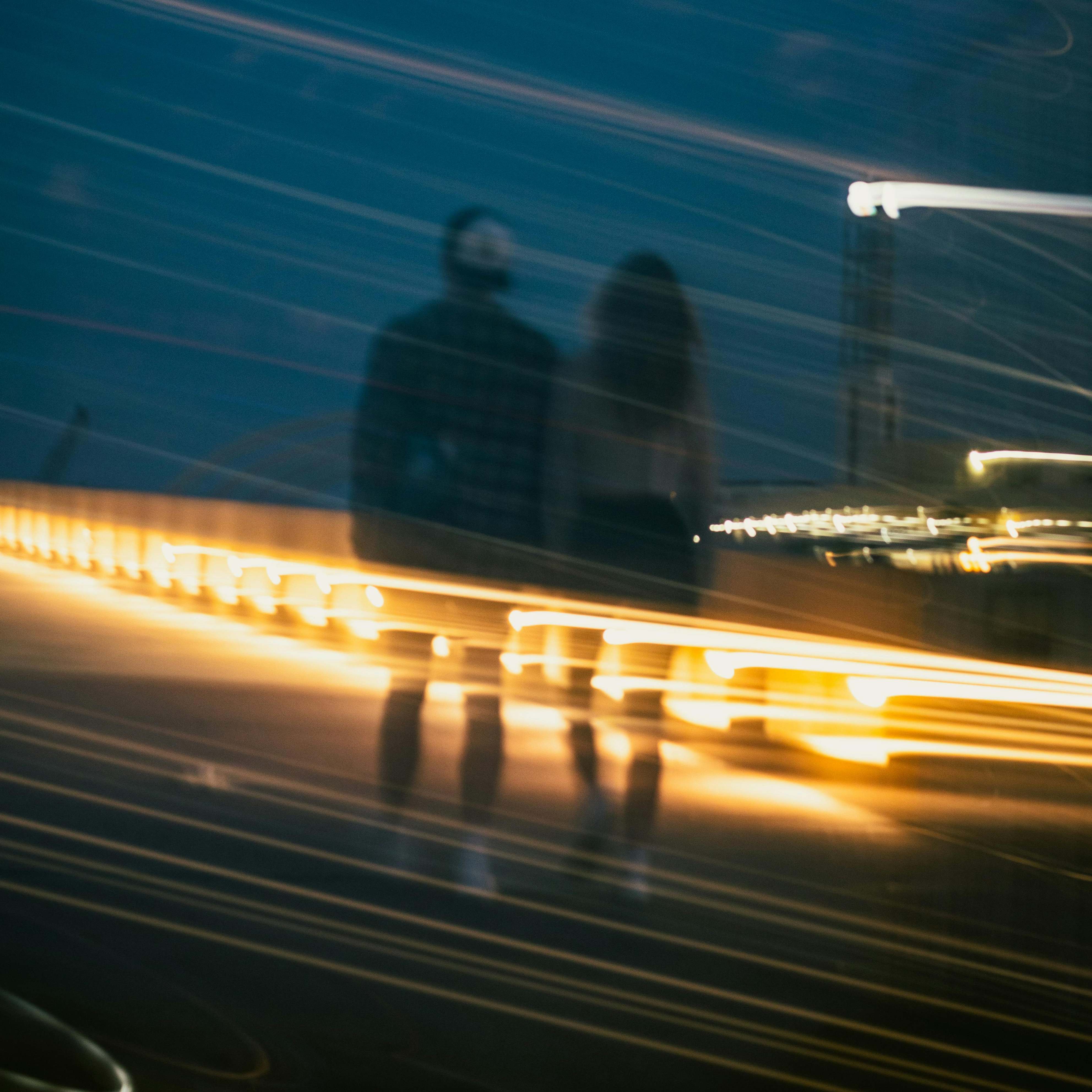 Un hombre y una mujer caminando juntos por una calle de noche | Fuente: Pexels