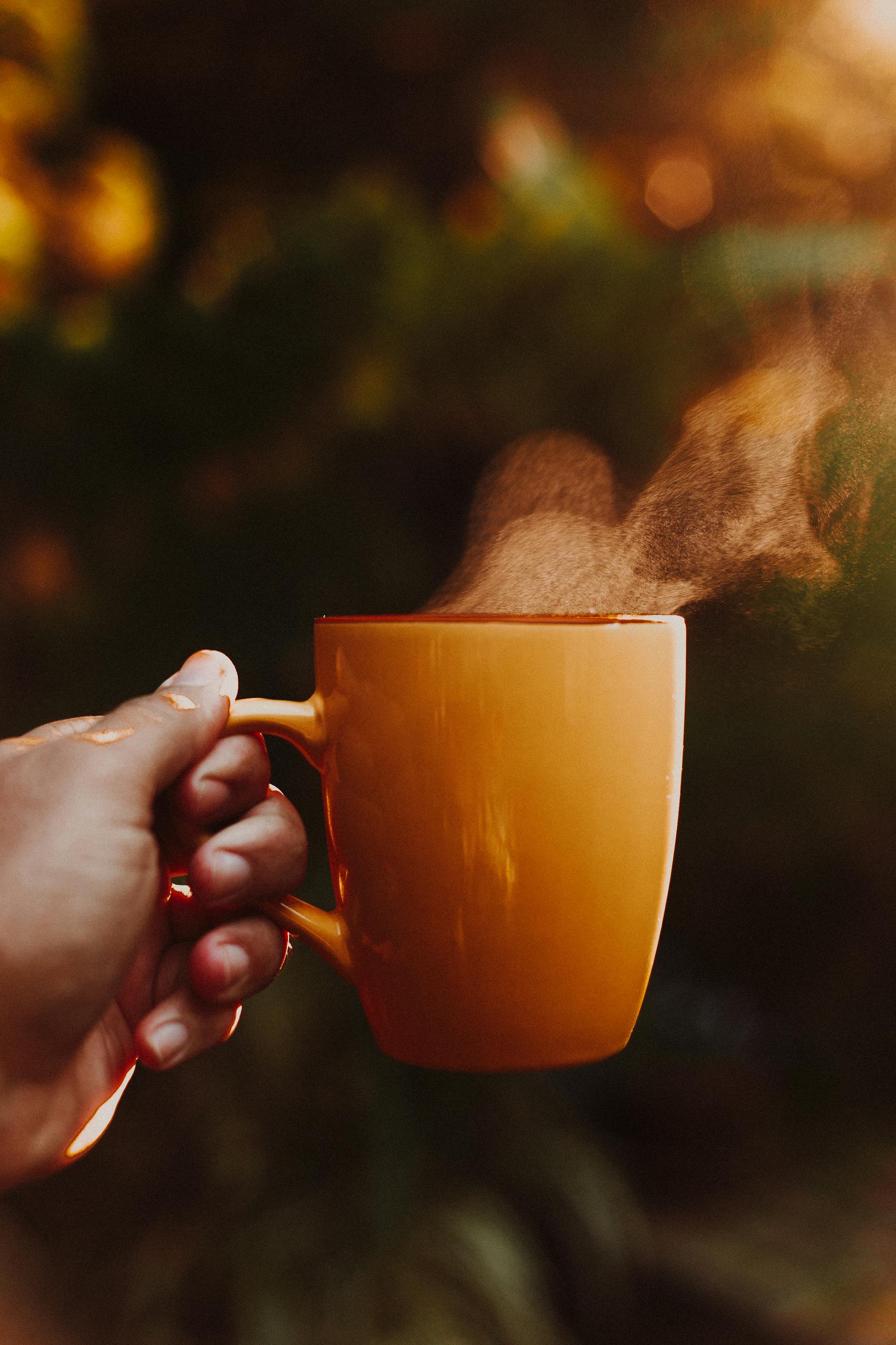 Una persona con una taza de café en la mano | Fuente: Pexels