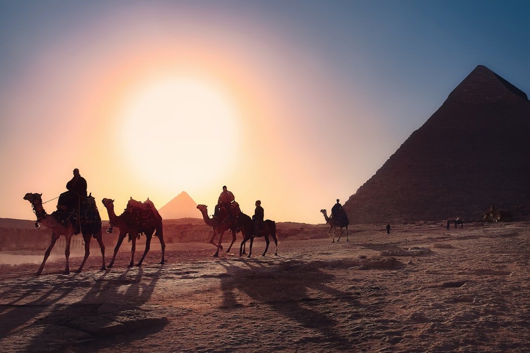Personas sobre camellos en el desierto. | Foto: Unsplash
