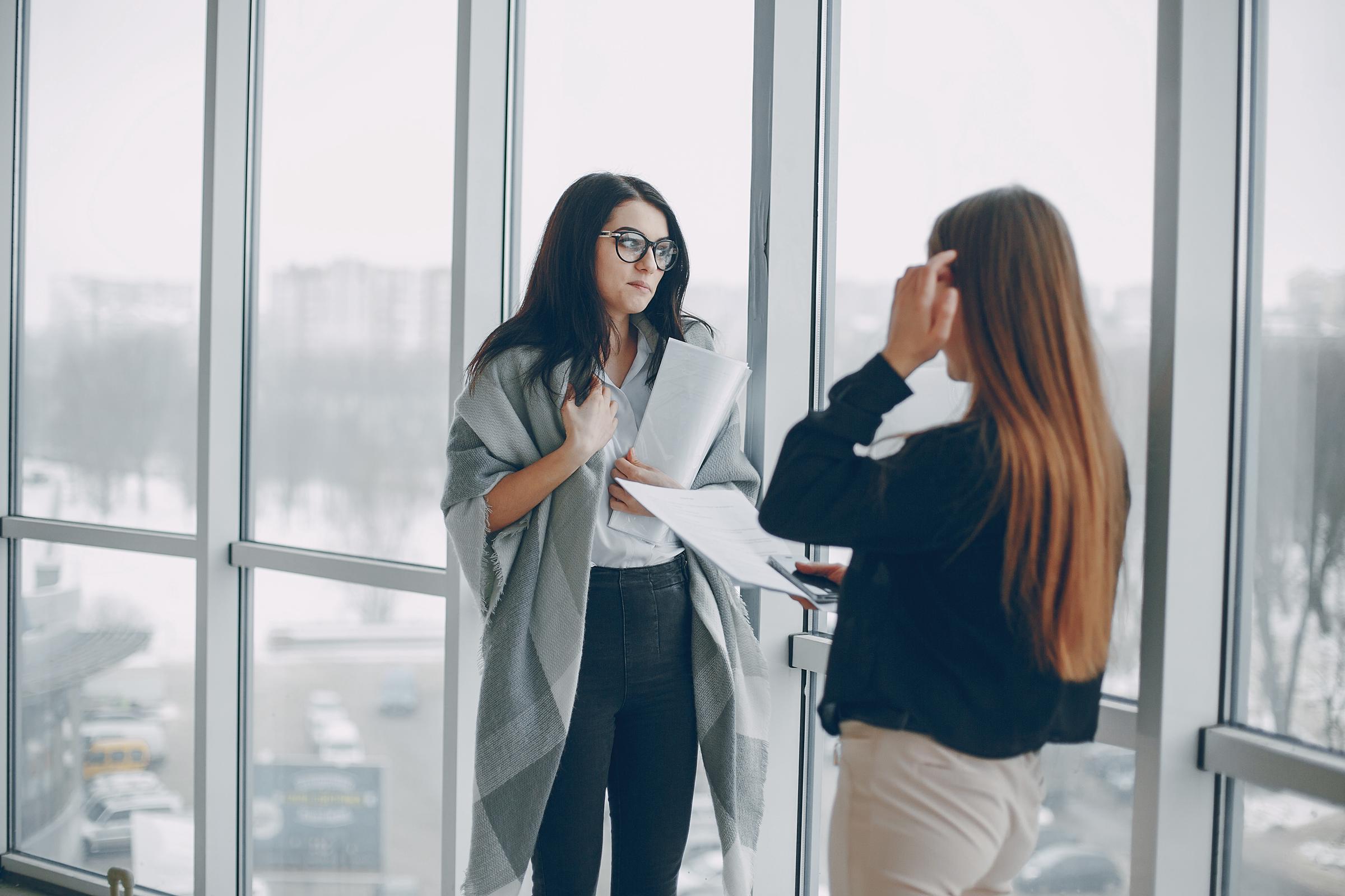 Dos mujeres charlando en su lugar de trabajo | Fuente: Freepik