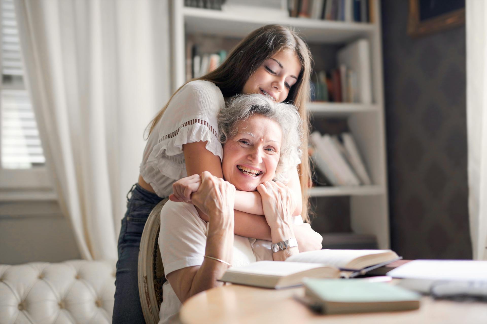 Una niña abrazando a su abuela por detrás | Fuente: Pexels