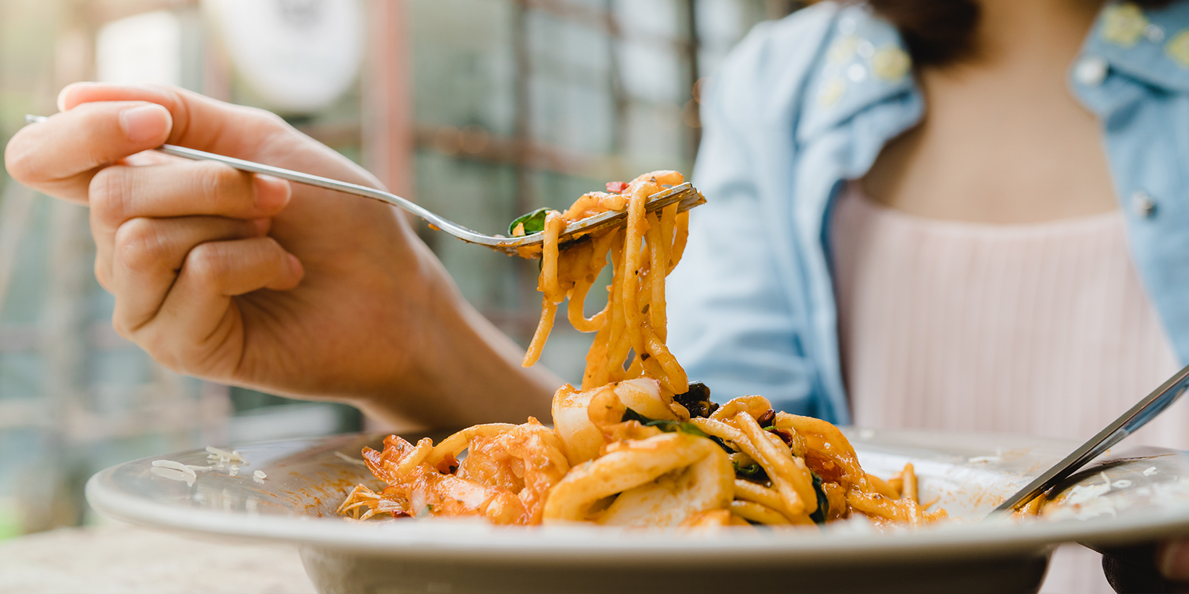 Primer plano de una mujer comiendo pasta | Fuente: Shutterstock