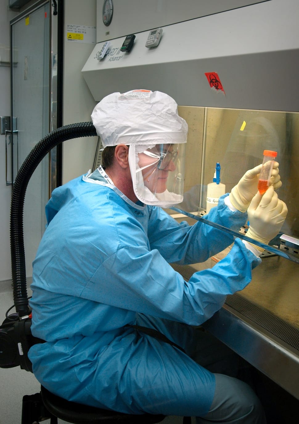 Hombre examina una muestra cubierto con un EPI. | Foto: Peakpx