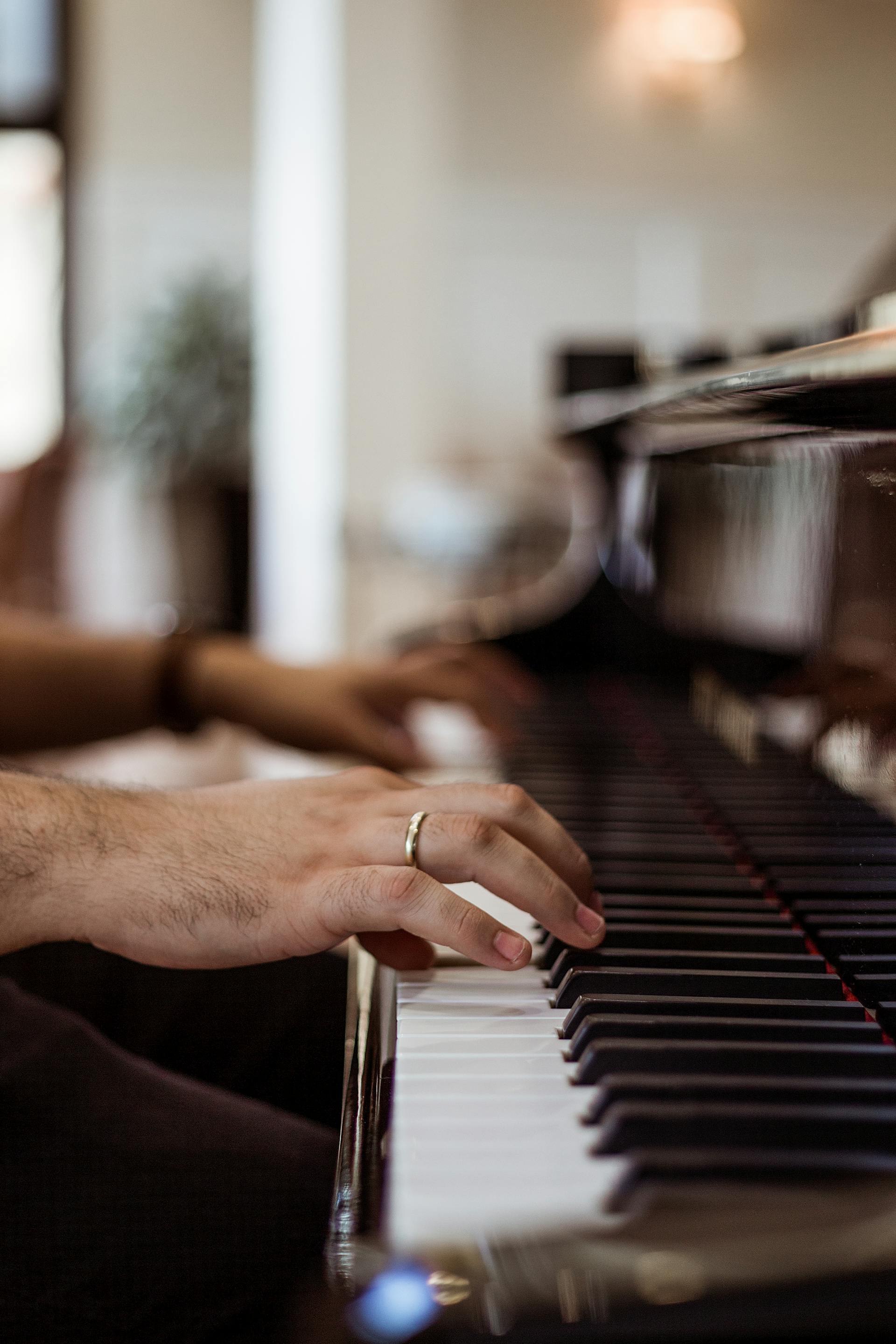 Primer plano de las manos de un hombre mientras toca el piano | Fuente: Pexels