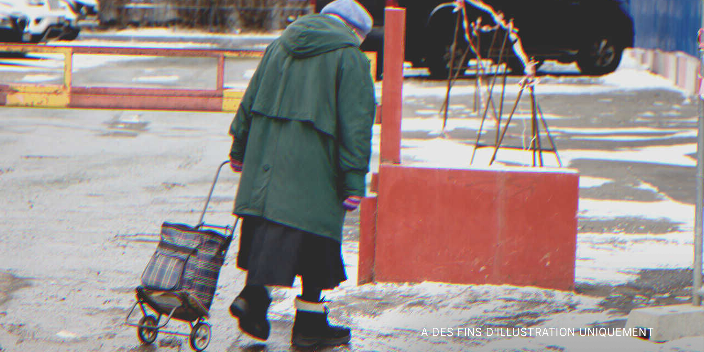 Dame âgée solitaire marchant dans une rue enneigée | Source : Shutterstock