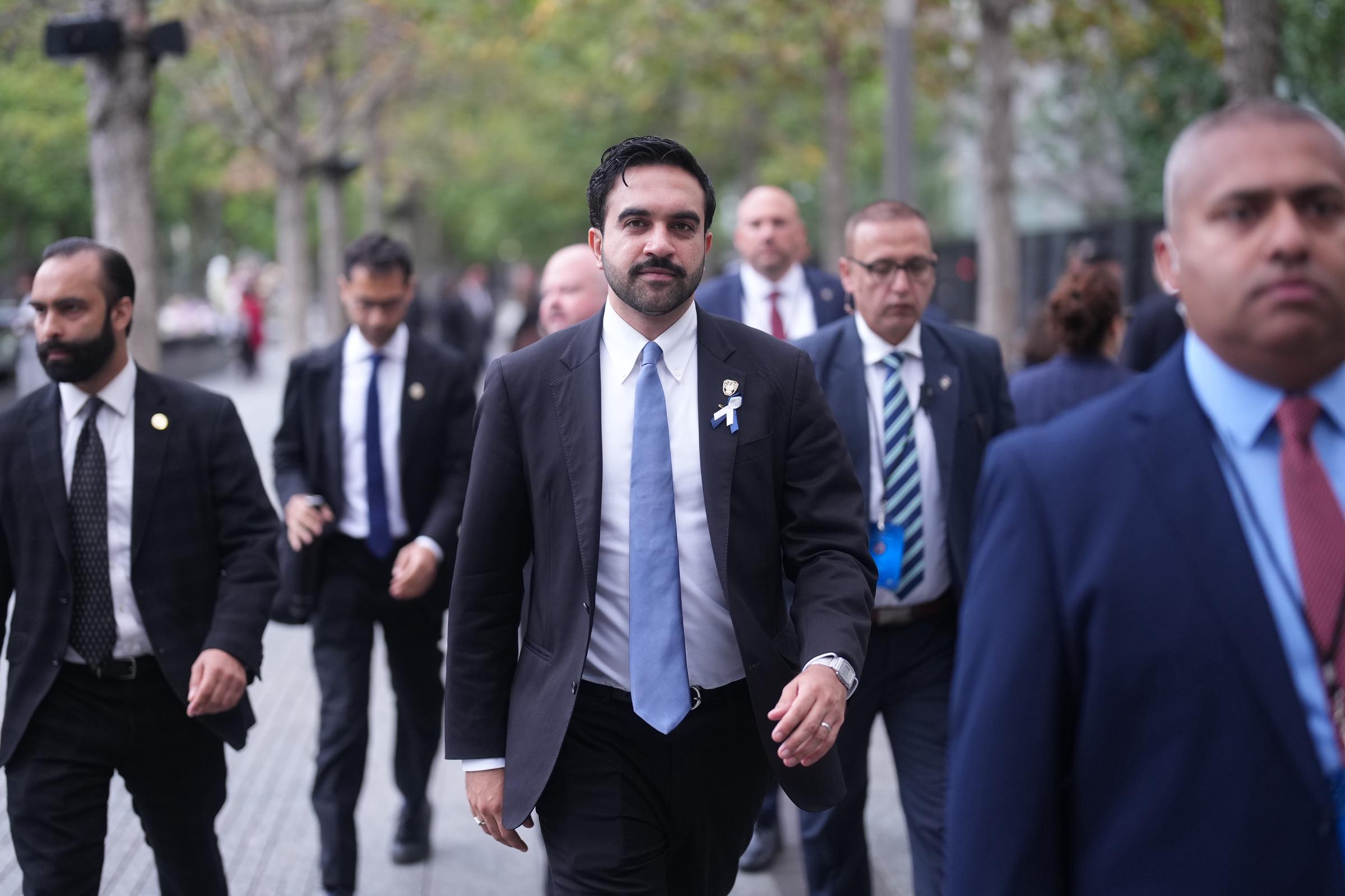 El alcalde Zohran Mamdani, en el centro, entra en el monumento conmemorativo antes de la ceremonia para recordar el 25.º aniversario de los atentados terroristas del 11 de septiembre contra el World Trade Center.   | Fuente: Getty Images