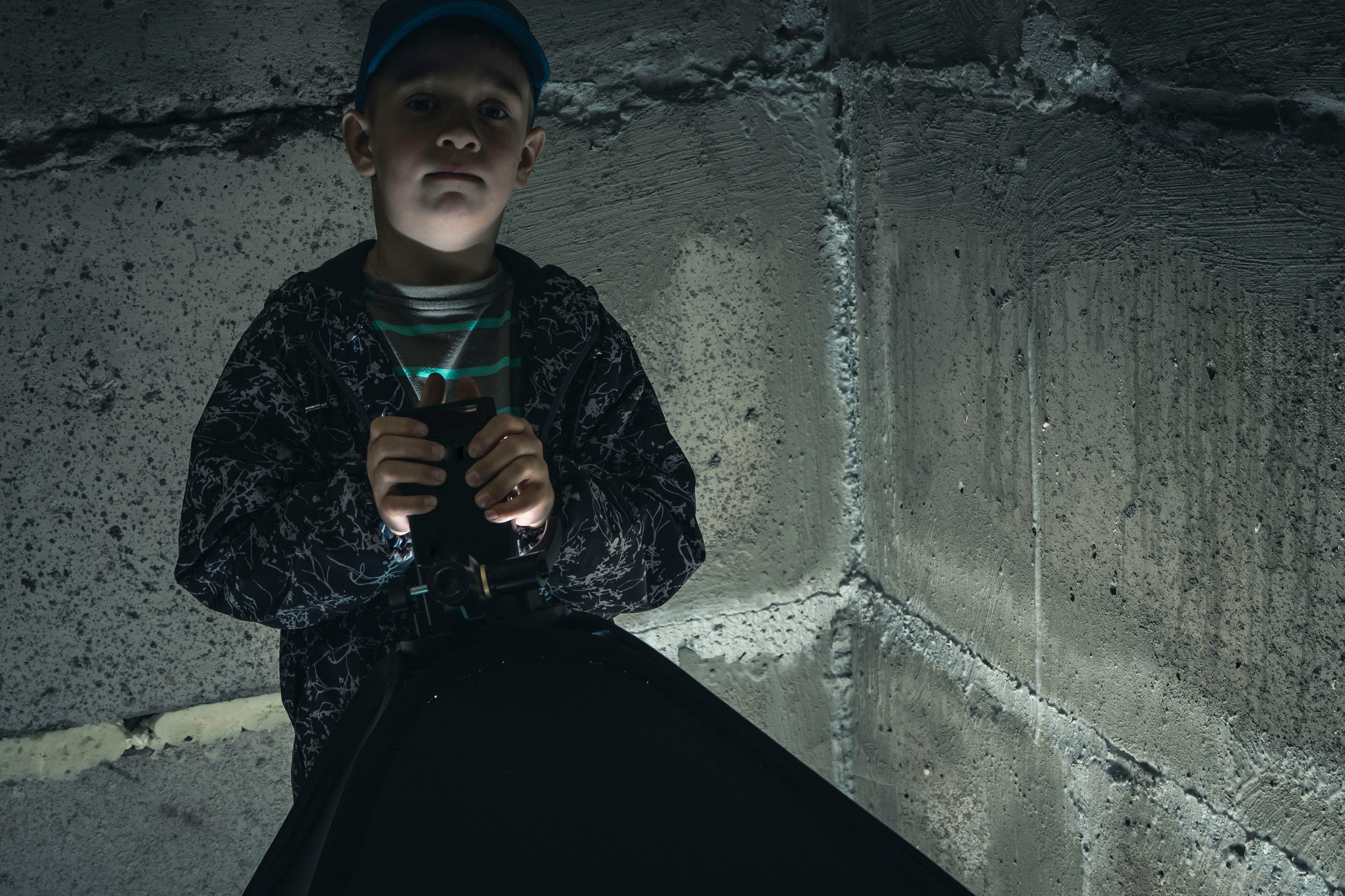 Niño en un oscuro sótano de hormigón. | Fuente: Shutterstock