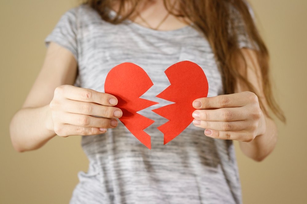 Mujer sosteniendo un corazón roto.| Fuente: Shutterstock