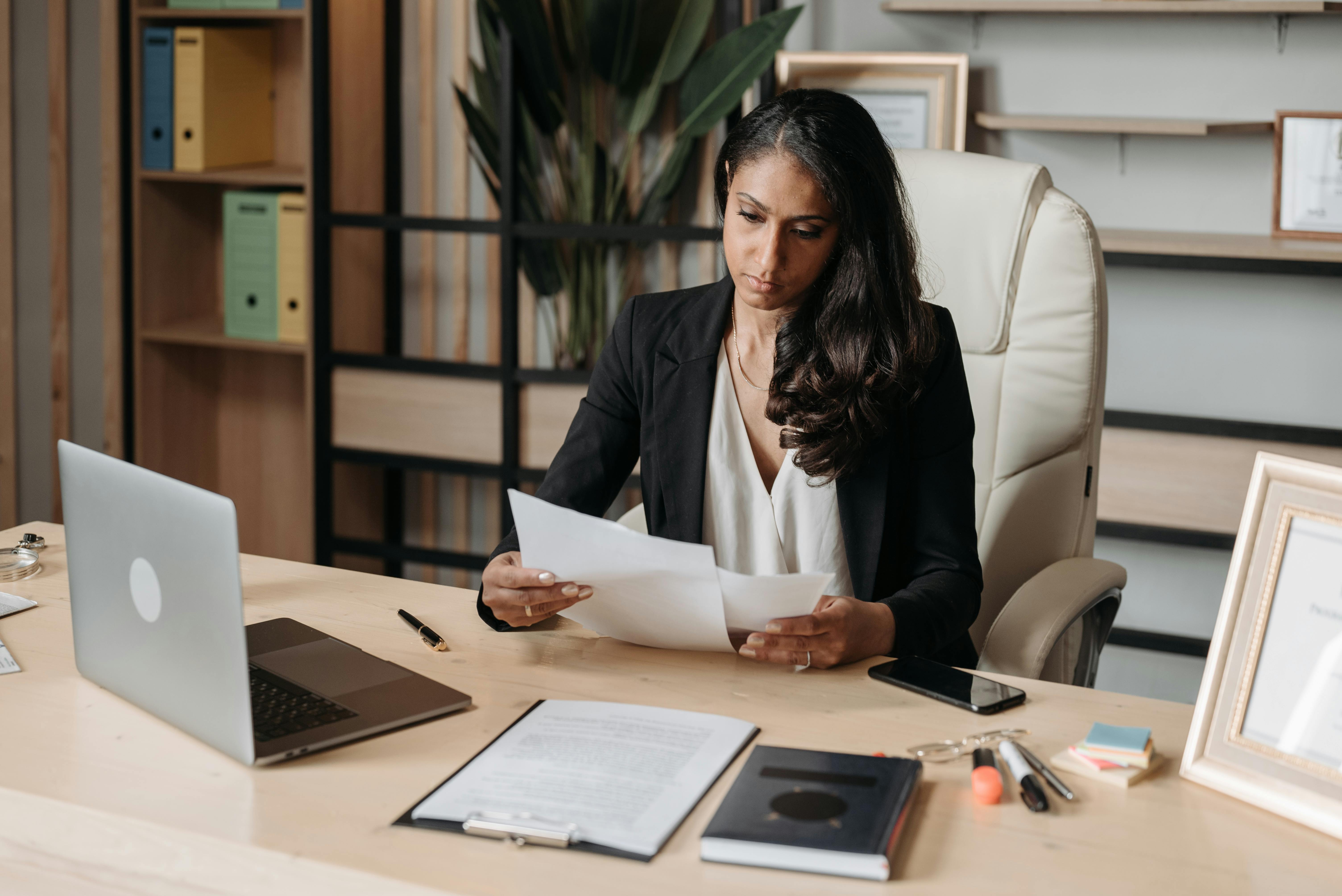 Una mujer trabajando en la mesa de su oficina | Fuente: Pexels