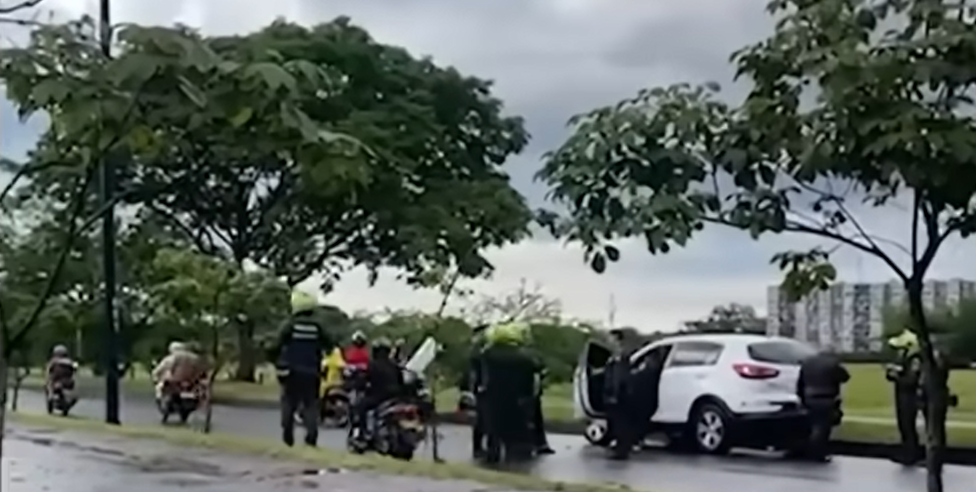Oficiales de la Policía de Villavicencio reunidos en una calle cerca del vehículo del joven que habría sido asesinado por su amigo | Fuente: YouTube/Noticias RCN