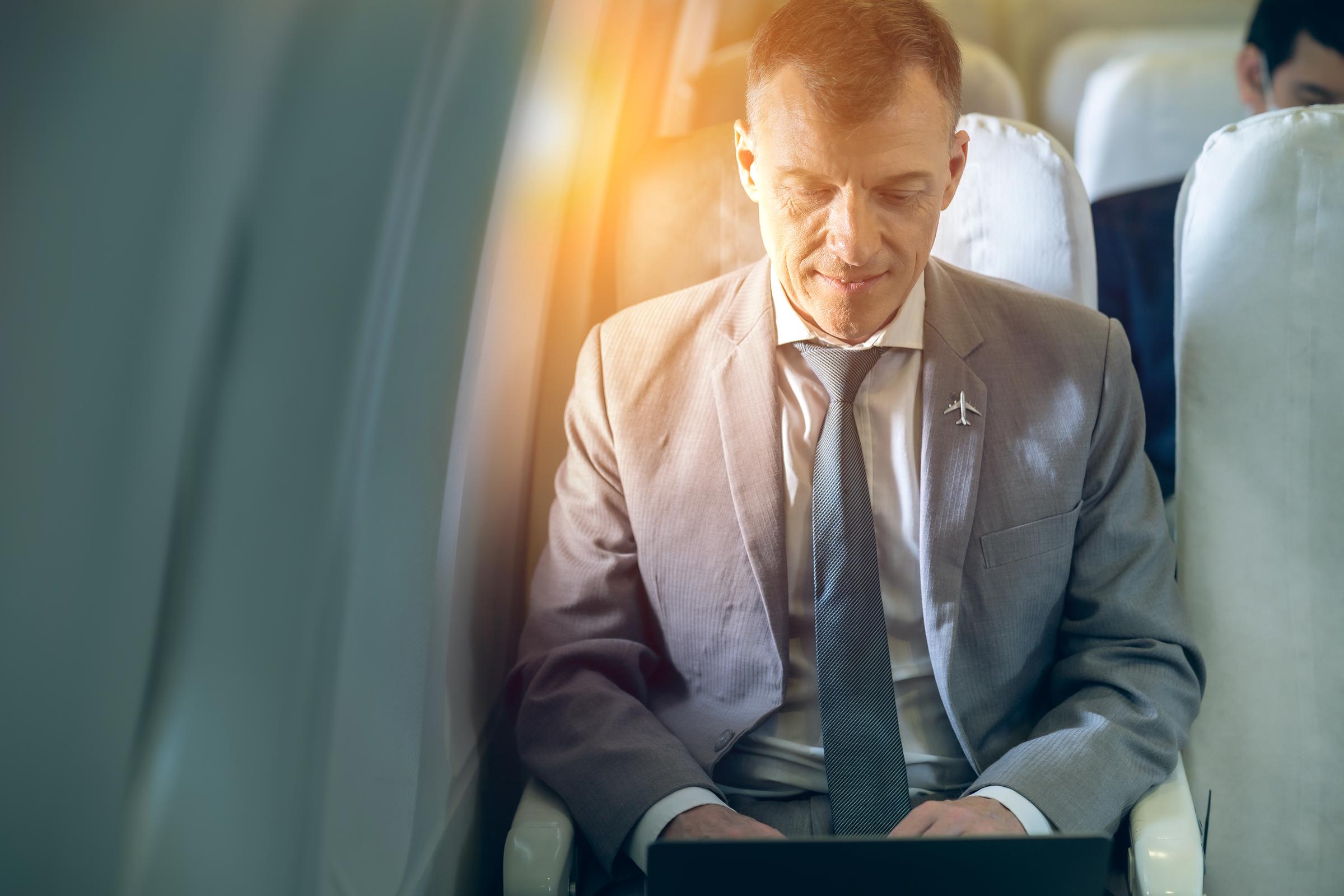 Hombre de negocios dentro de un avión | Fuente: Shutterstock