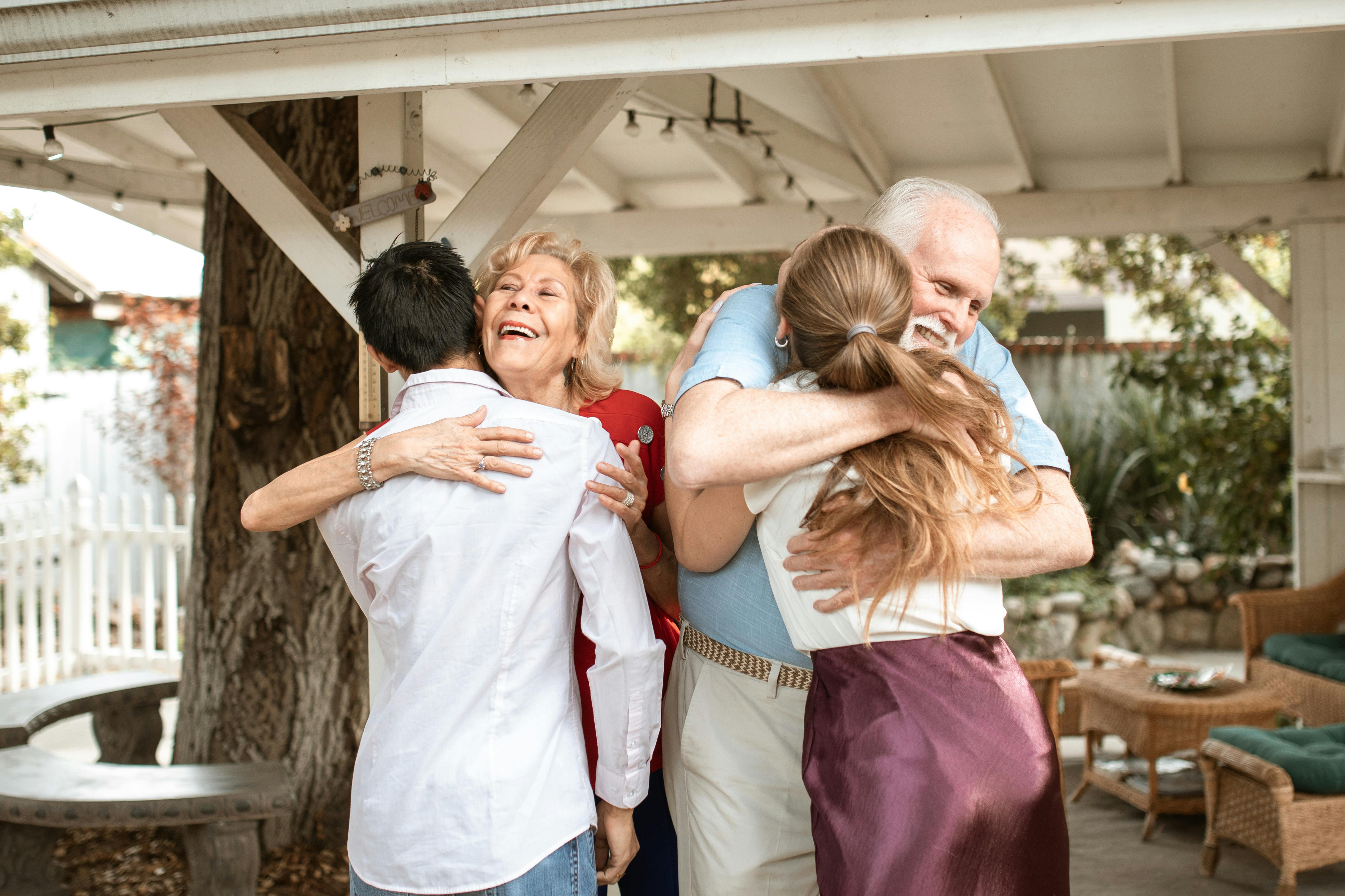Una familia de cuatro personas compartiendo abrazos | Fuente: Pexels