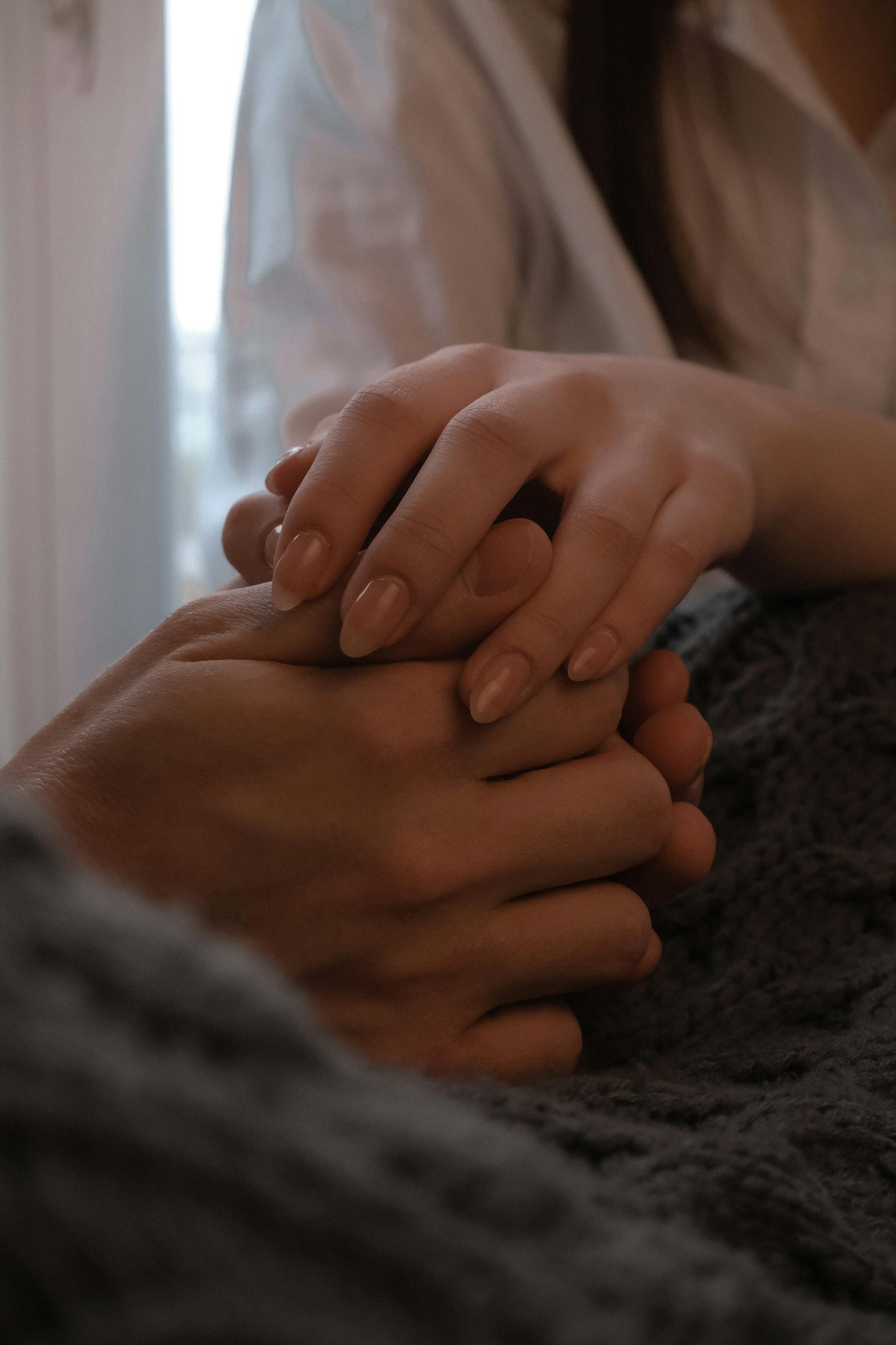 Primer plano de una pareja tomada de la mano | Fuente: Pexels