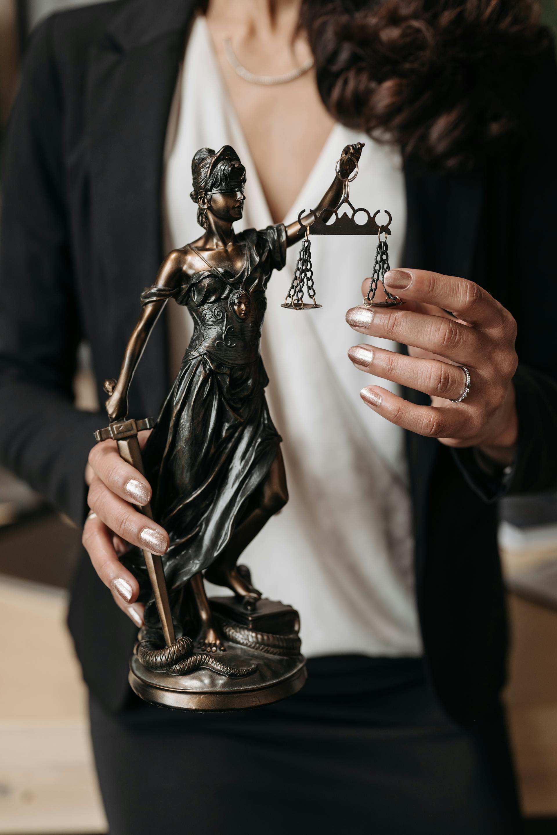 Primer plano de una mujer que sostiene una estatuilla de la Dama de la Justicia | Fuente: Pexels