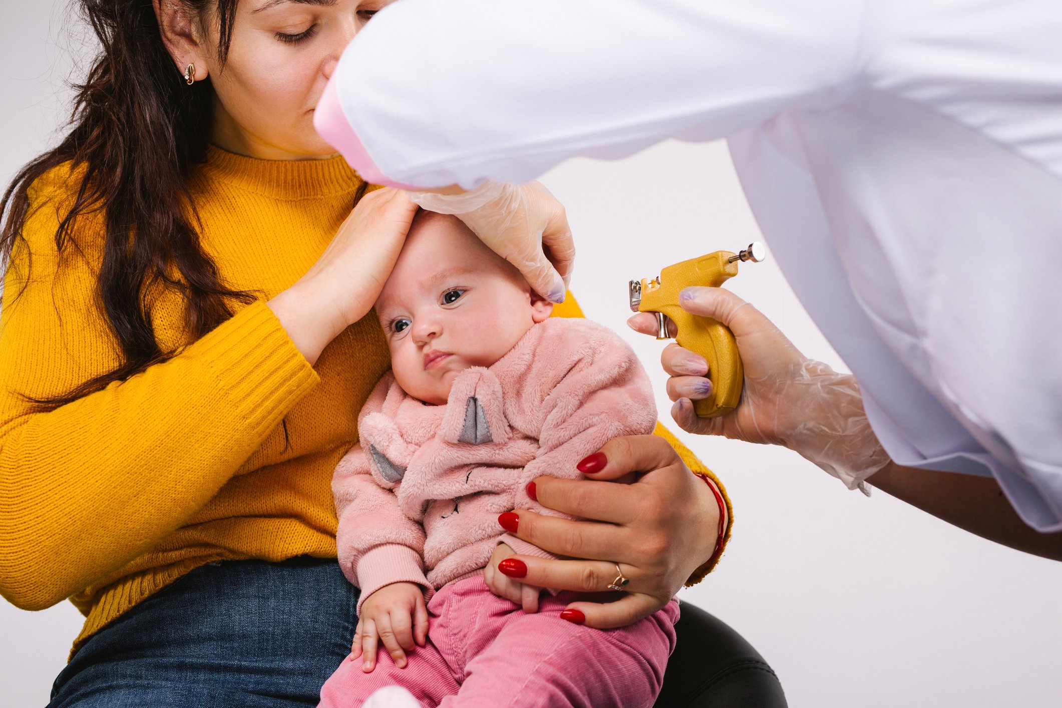 Persona perforando oreja a bebita. | Foto: Getty Images 