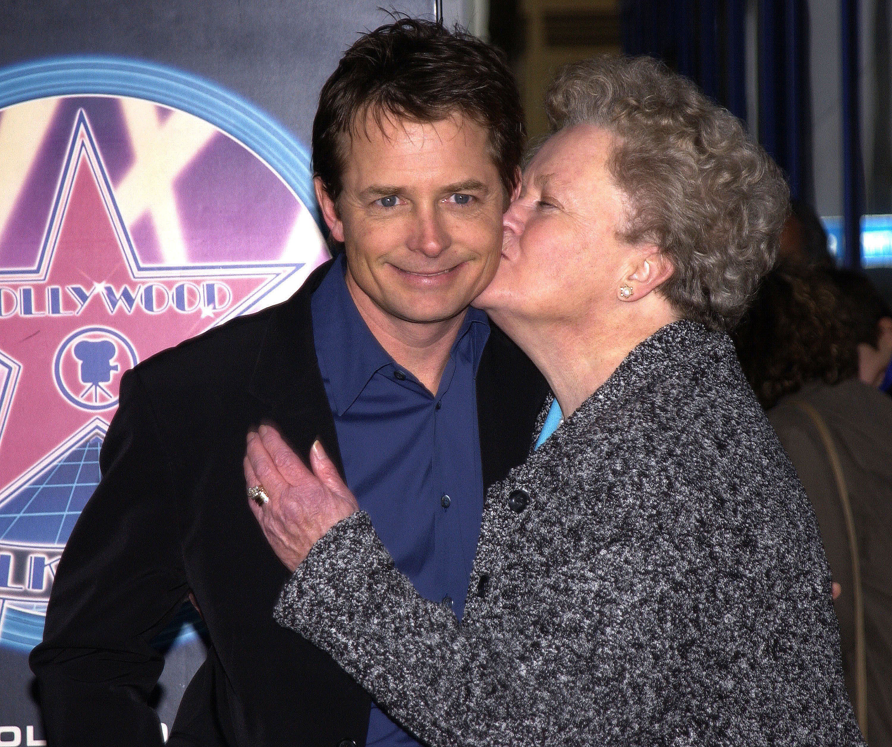 Michael J. Fox y su madre Phyllis durante su tributo con una estrella en el Paseo de la Fama en Hollywood Boulevard, California, el 16 de diciembre de 2002. | Foto: Getty Images