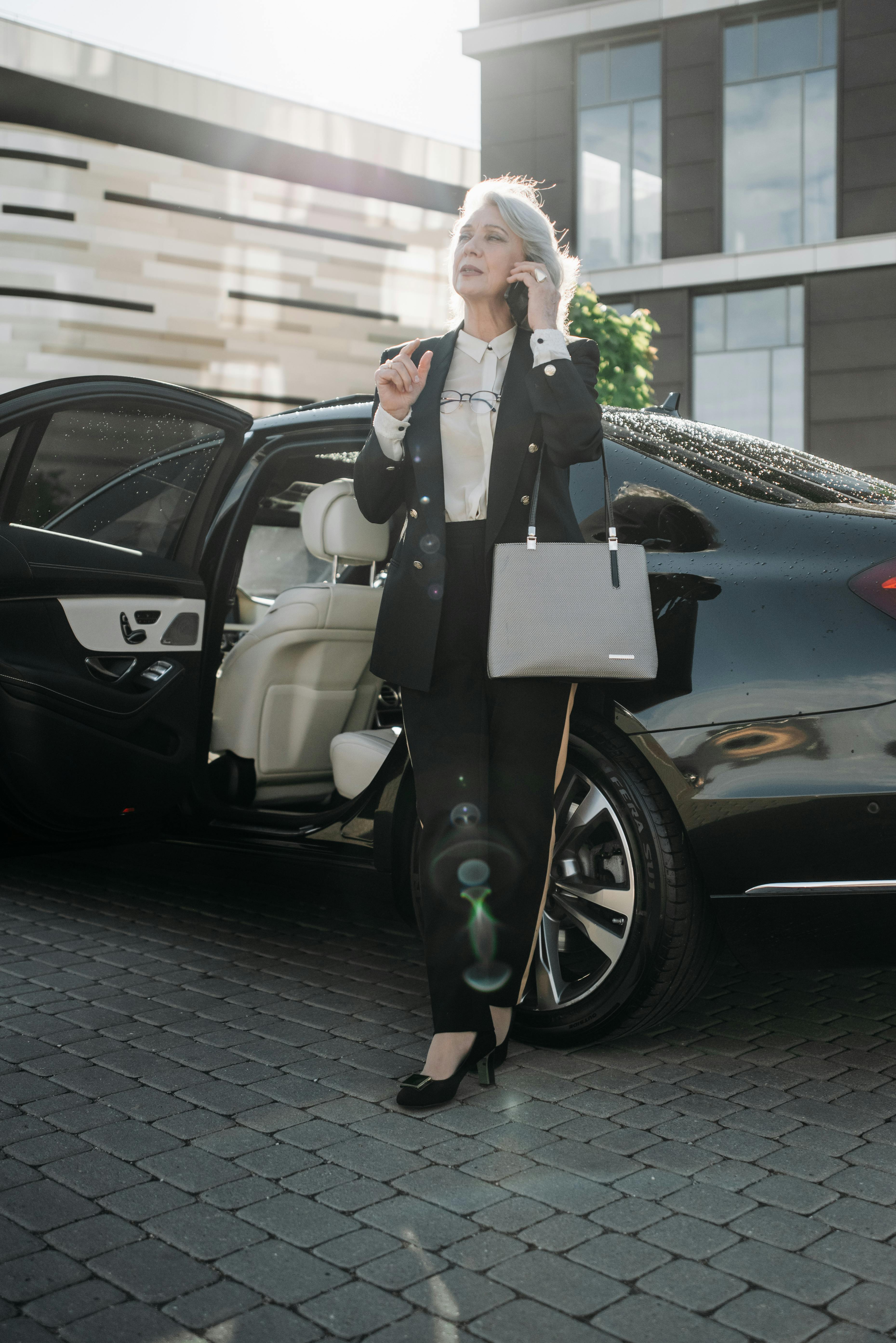 Una mujer junto a un automóvil caro | Foto: Pexels