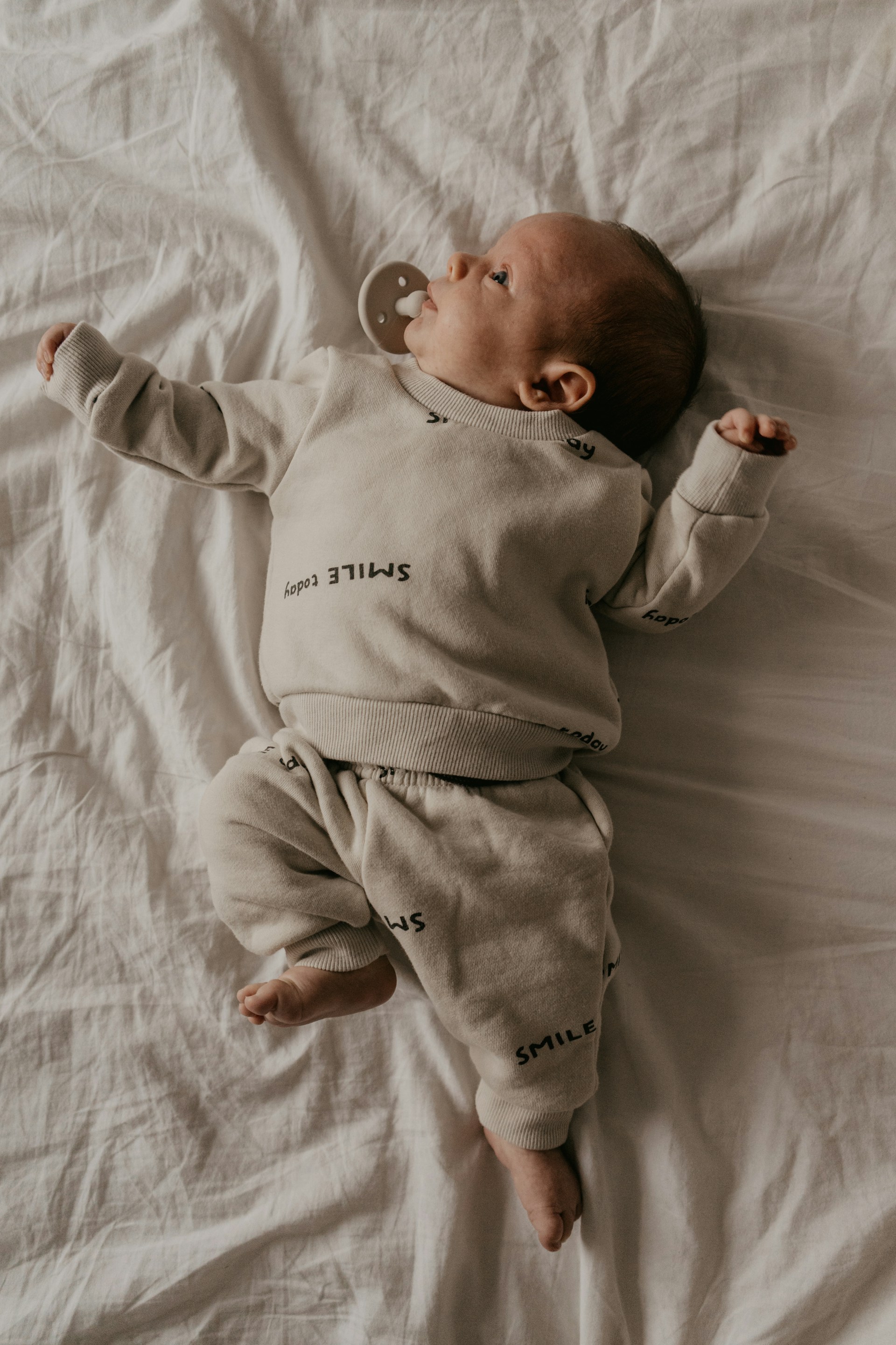 Un adorable bebé tumbado en la cama | Fuente: Unsplash