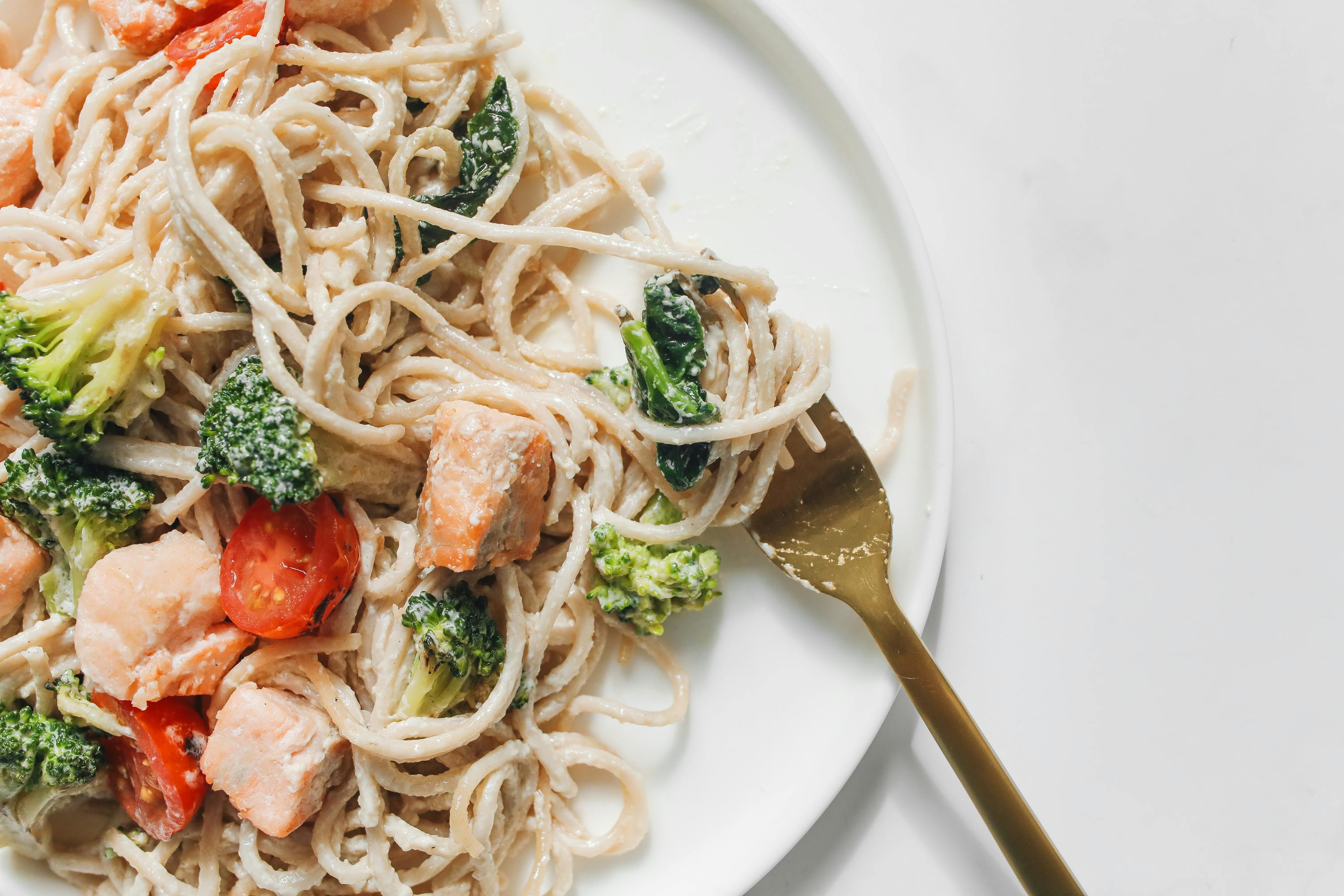 Pasta con verduras y carne en un plato blanco | Fuente: Pexels