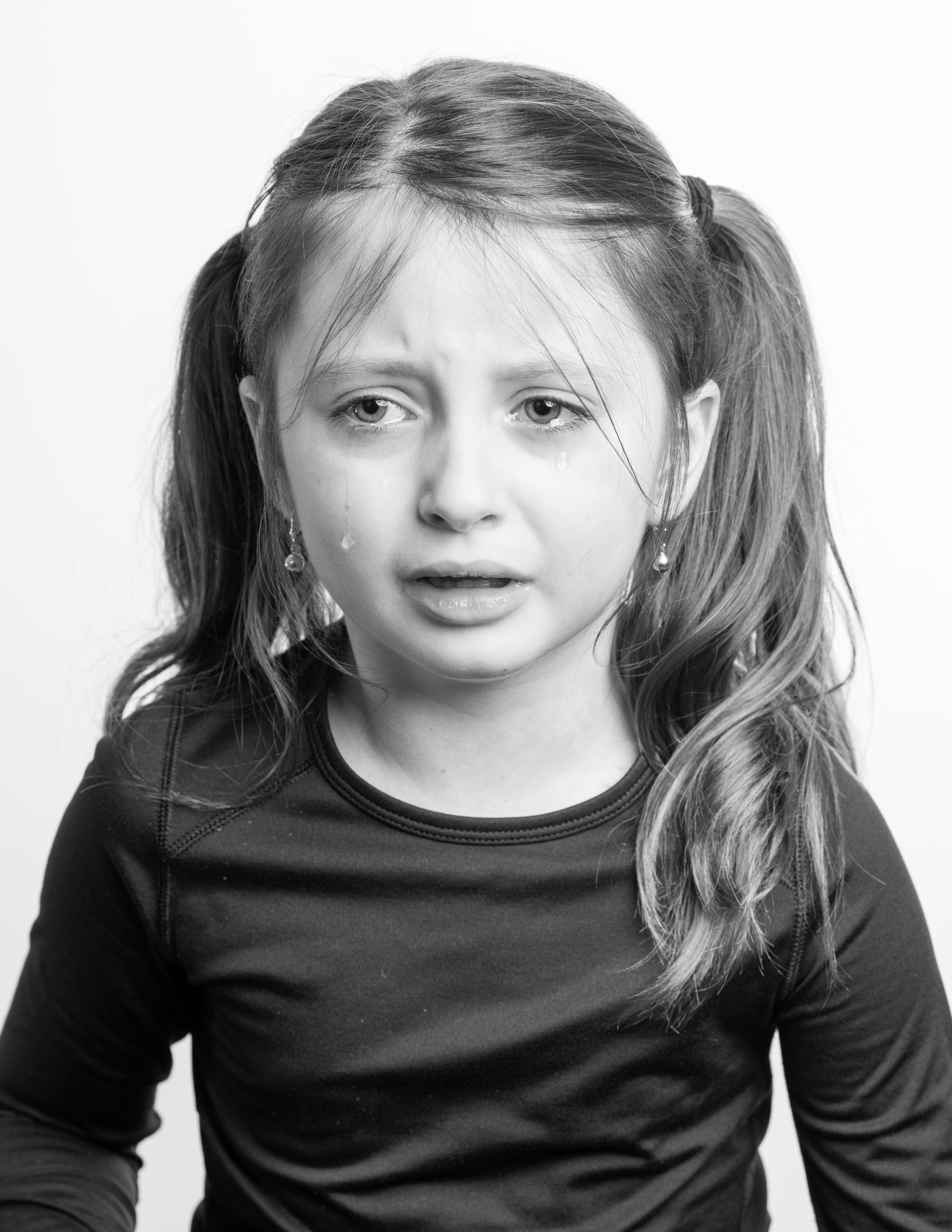 Una imagen en blanco y negro de una niña llorando | Foto: Pexels
