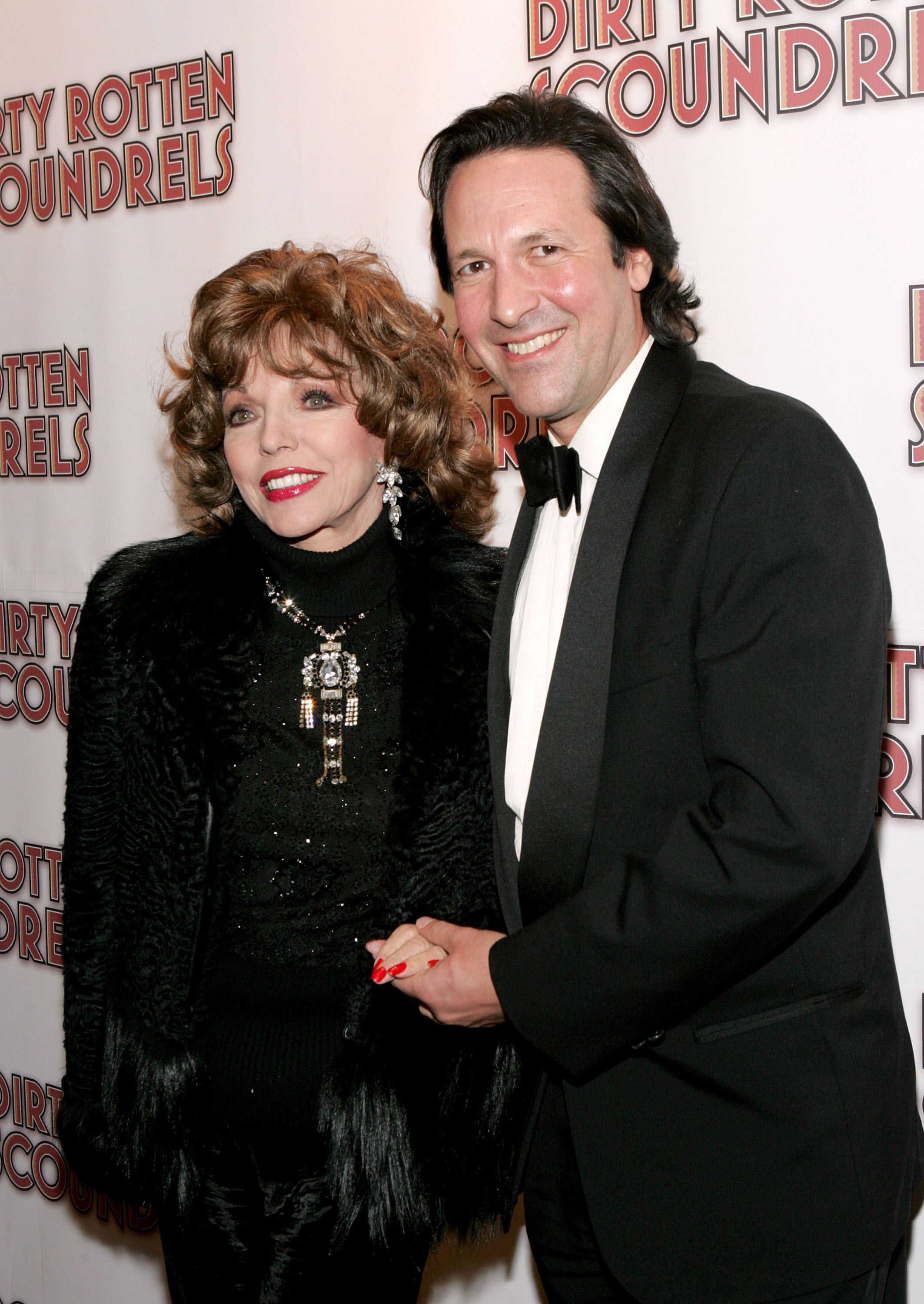 Joan Collins, con esmalte de uñas rojo, con su marido Percy Gibson el 3 de marzo de 2005, en Nueva York | Foto: Getty Images