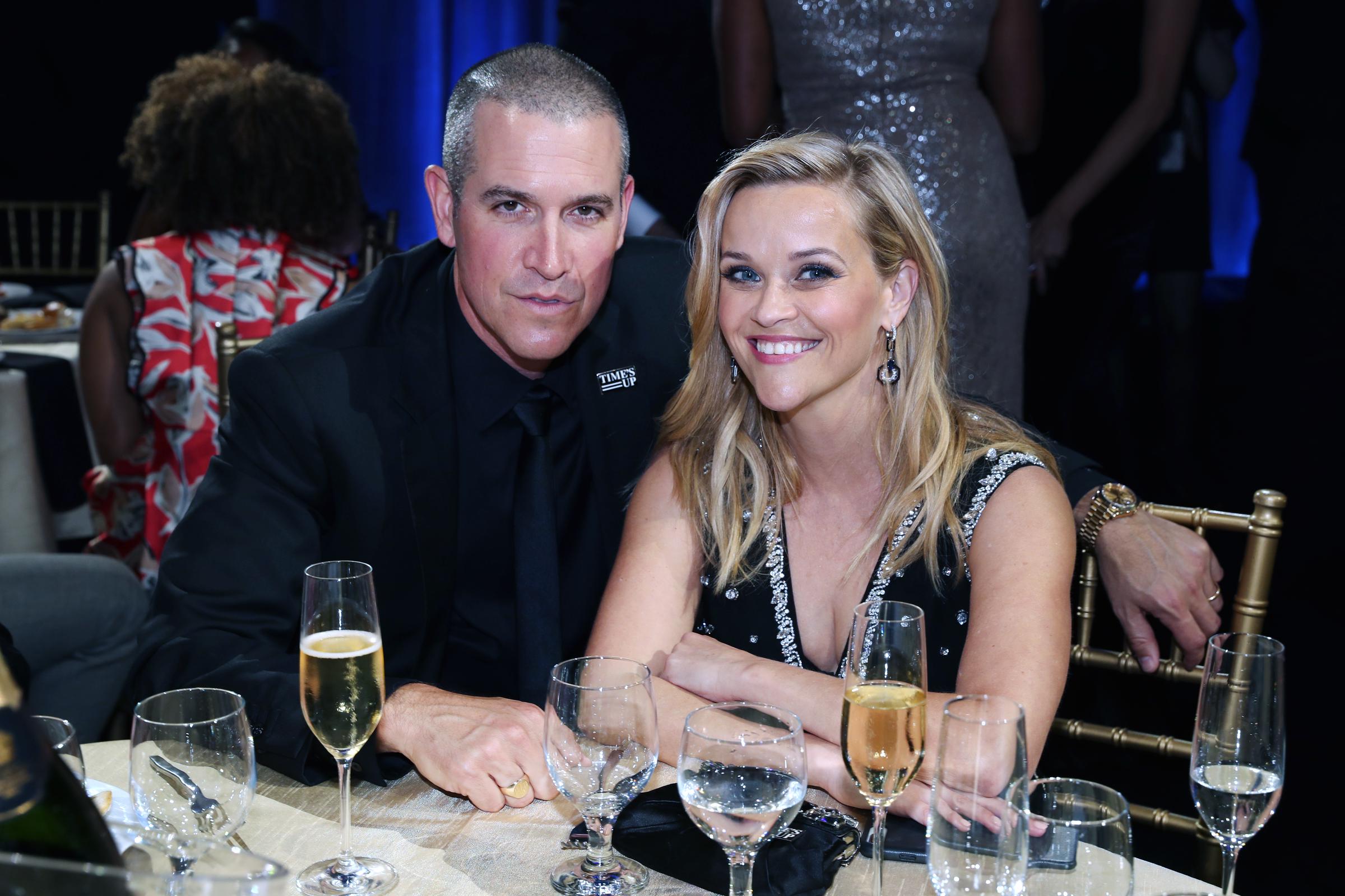 Jim Toth y Witherspoon están sentados en una mesa disfrutando de unas bebidas mientras asisten a la 23ª edición de los Critics' Choice Awards en el Barker Hangar el 11 de enero de 2018, en Santa Mónica, California.