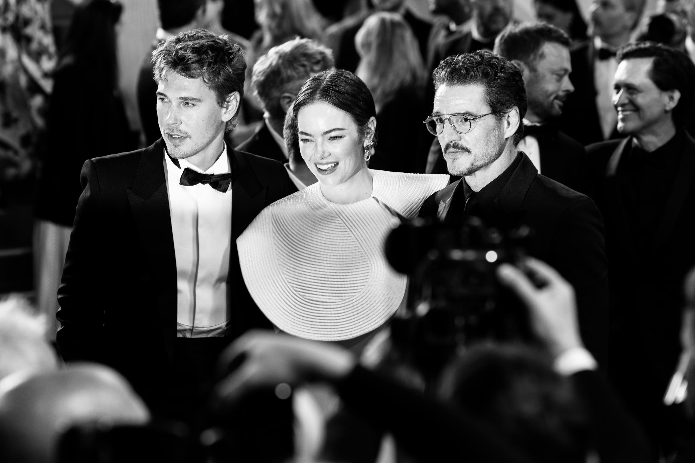 Austin Butler, Emma Stone y Pedro Pascal posan para los fotógrafos en el estreno de "Eddington", capturados aquí en un impactante momento en blanco y negro. El trío irradia un glamour moderno: Stone luce un vestido blanco de corte escultórico, con sus coprotagonistas en clásicos esmóquines.