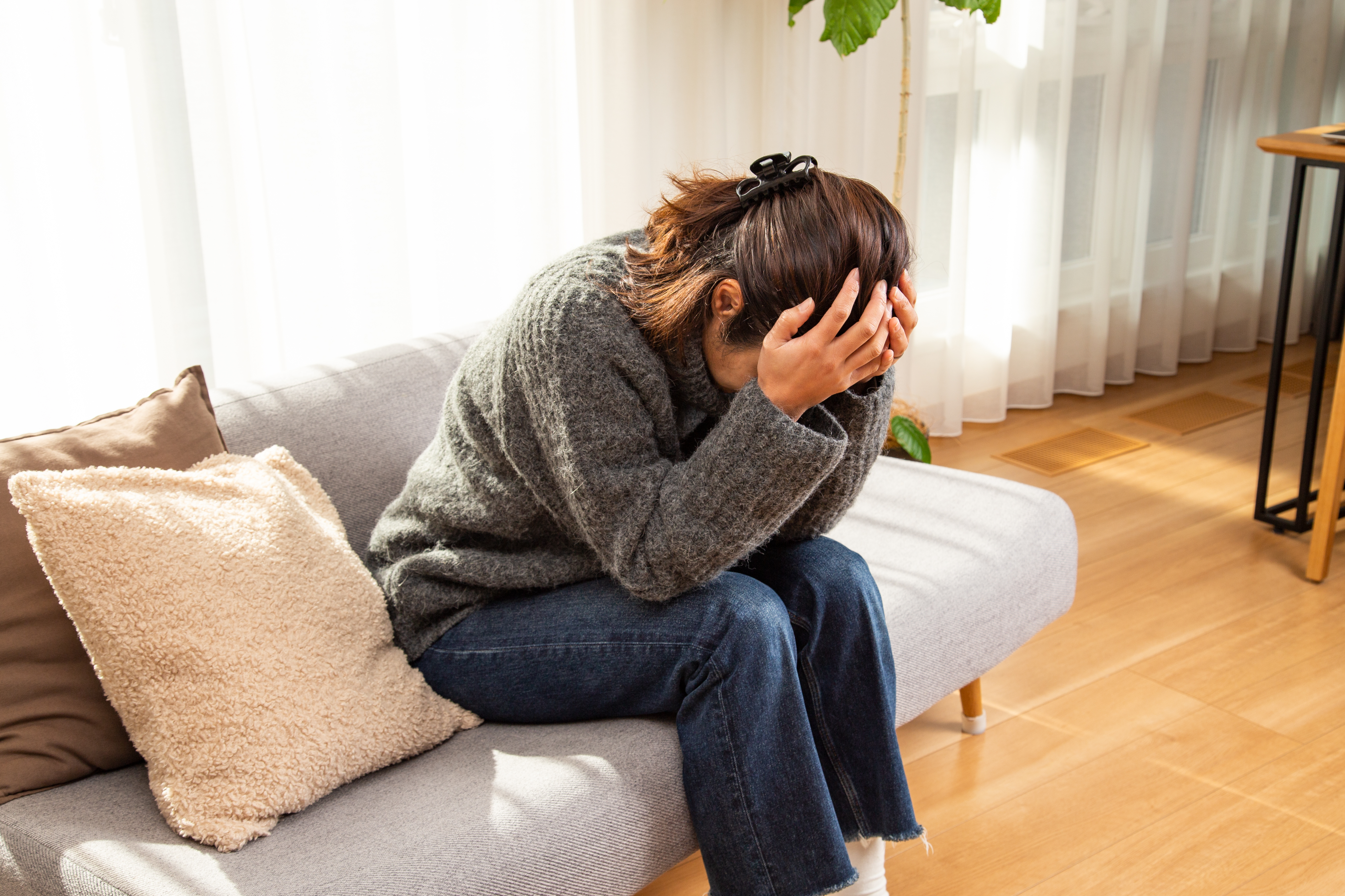 Una mujer sujetándose la cabeza en el salón | Fuente: Getty Images