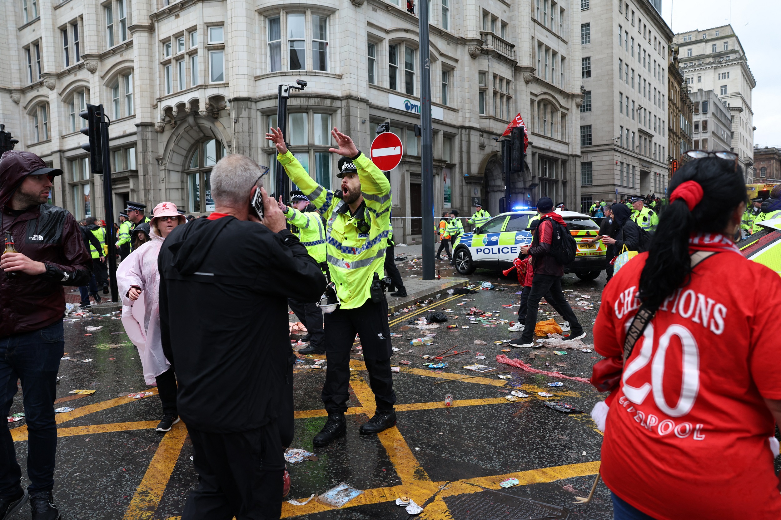 Un agente de policía grita a los aficionados del Liverpool mientras está de servicio en un cordón policial a la entrada de Water Street, durante el desfile de la victoria del Liverpool en autobús descapotado por la consecución del título de la Premier League, en Liverpool, noroeste de Inglaterra, el 26 de mayo de 2025 | Fuente: Getty Images