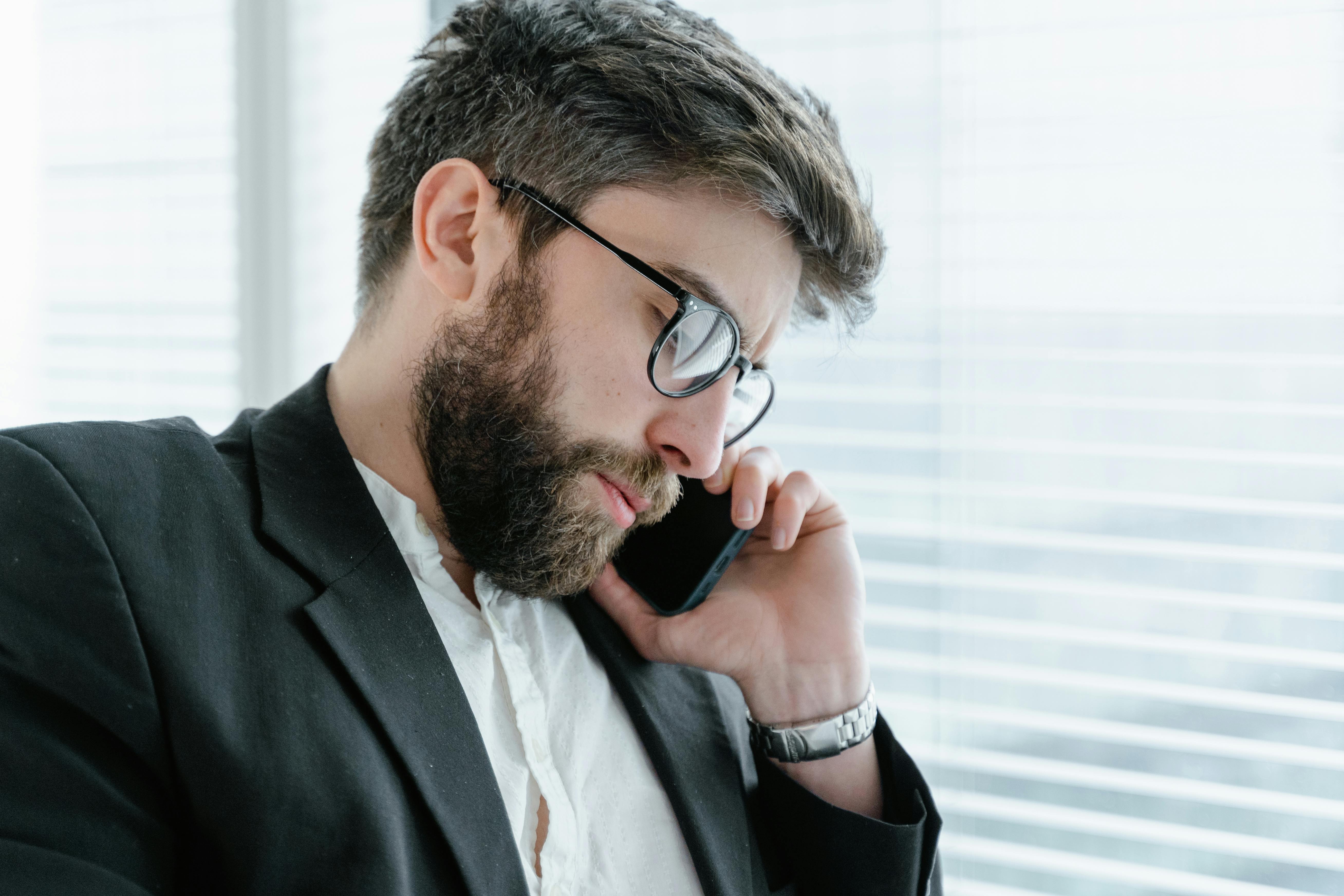 Hombre trajeado haciendo una llamada telefónica | Fuente: Pexels