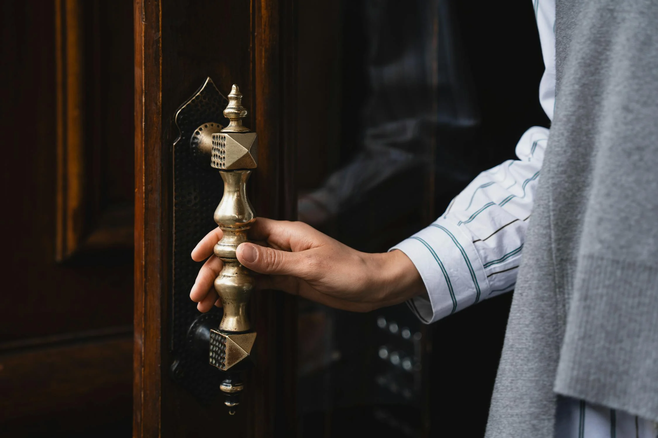 Una mujer sujetando la manilla de una puerta | Fuente: Pexels