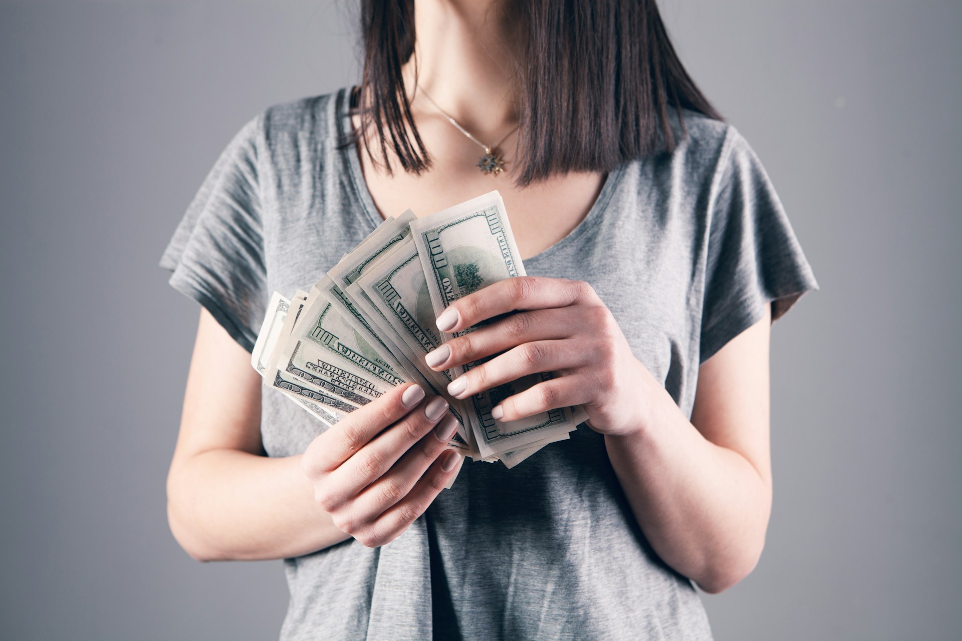 Una mujer con dinero en la mano | Fuente: Unsplash
