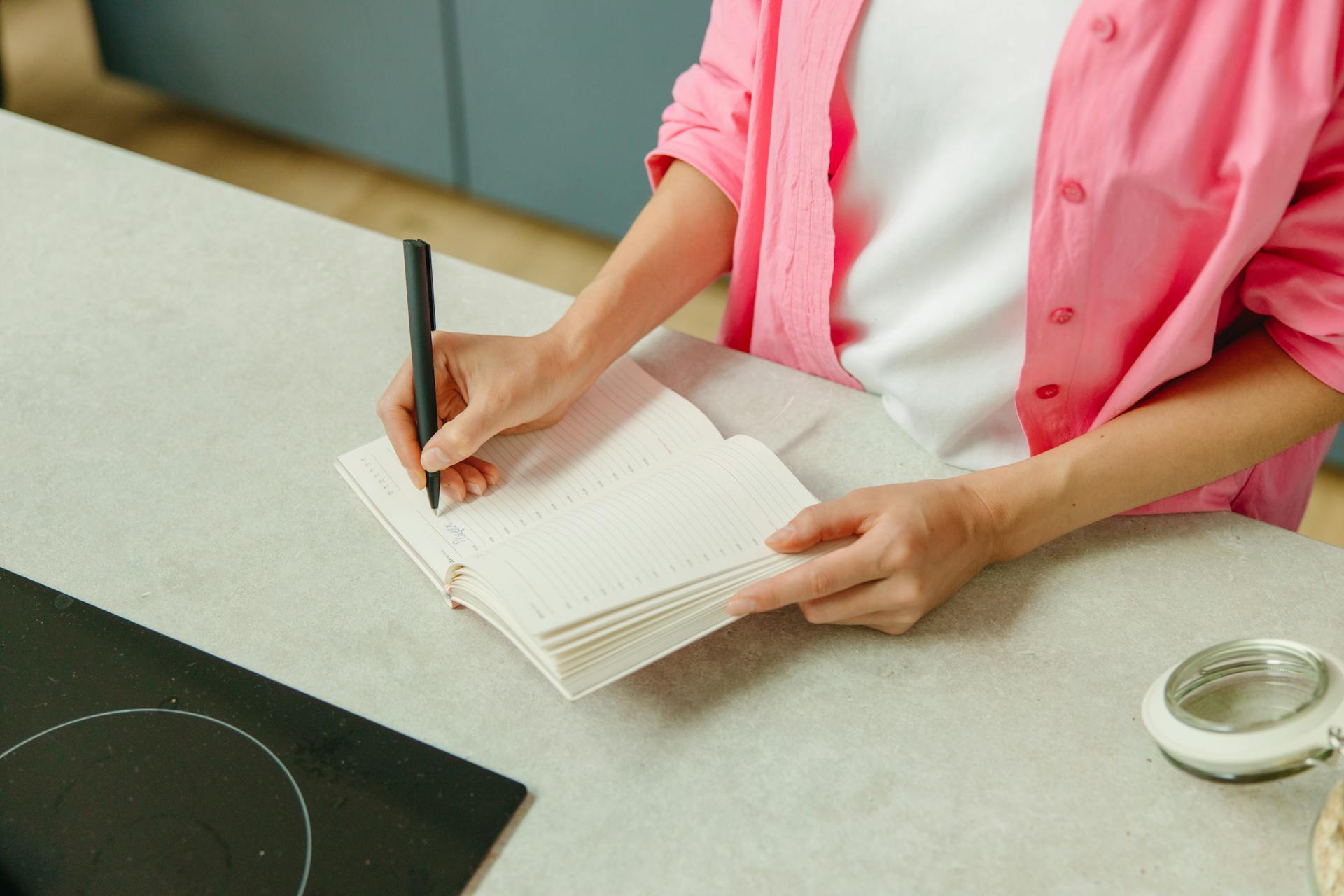 Primer plano de una mujer escribiendo en un cuaderno | Fuente: Pexels