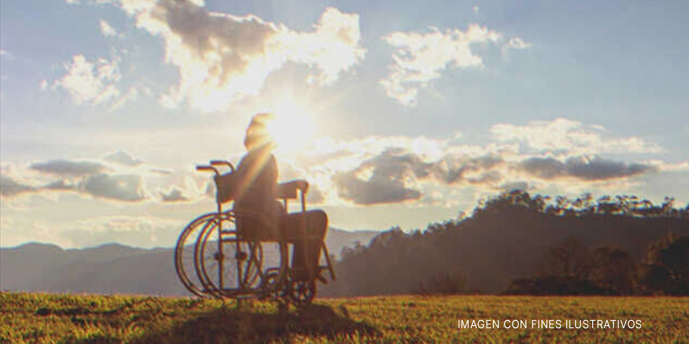 Persona en silla de ruedas a contraluz en un paisaje montañoso. | Foto: Shutterstock