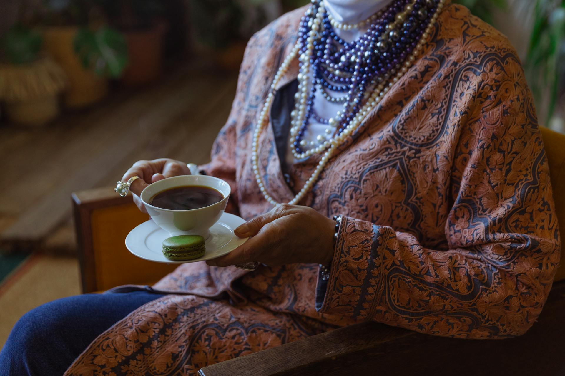 Una elegante mujer mayor con una taza de café en la mano | Fuente: Pexels