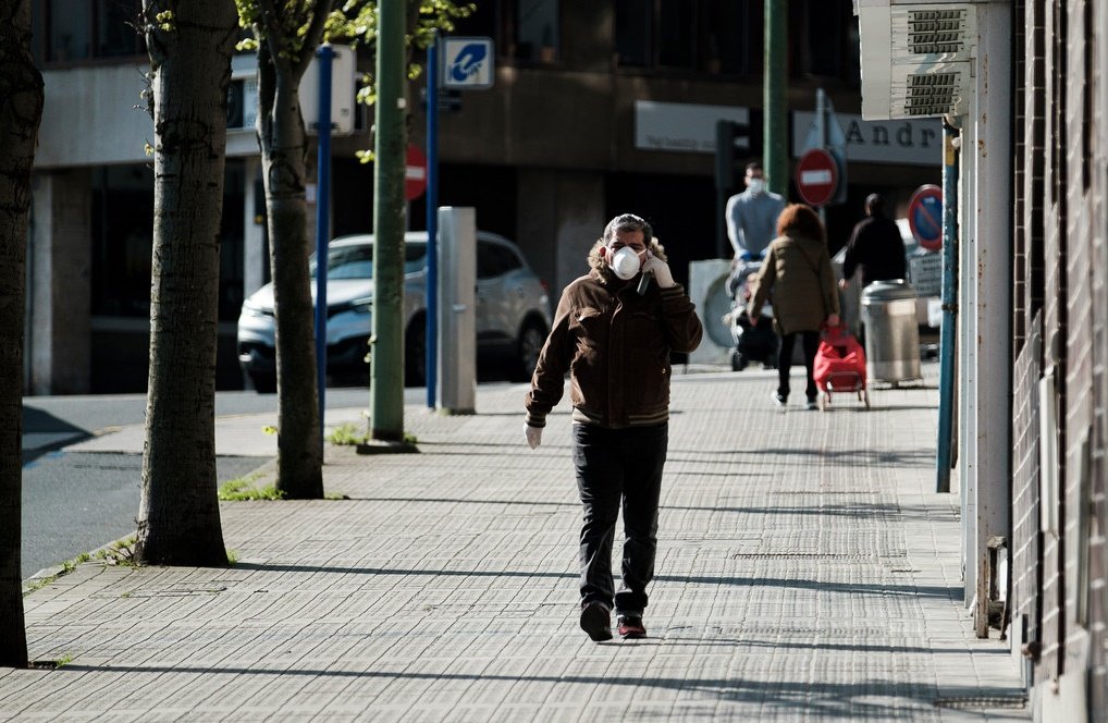 Hombre camina por una calle de España protegiéndose con una mascarilla durante la cuarentena. | Foto: Wikipedia