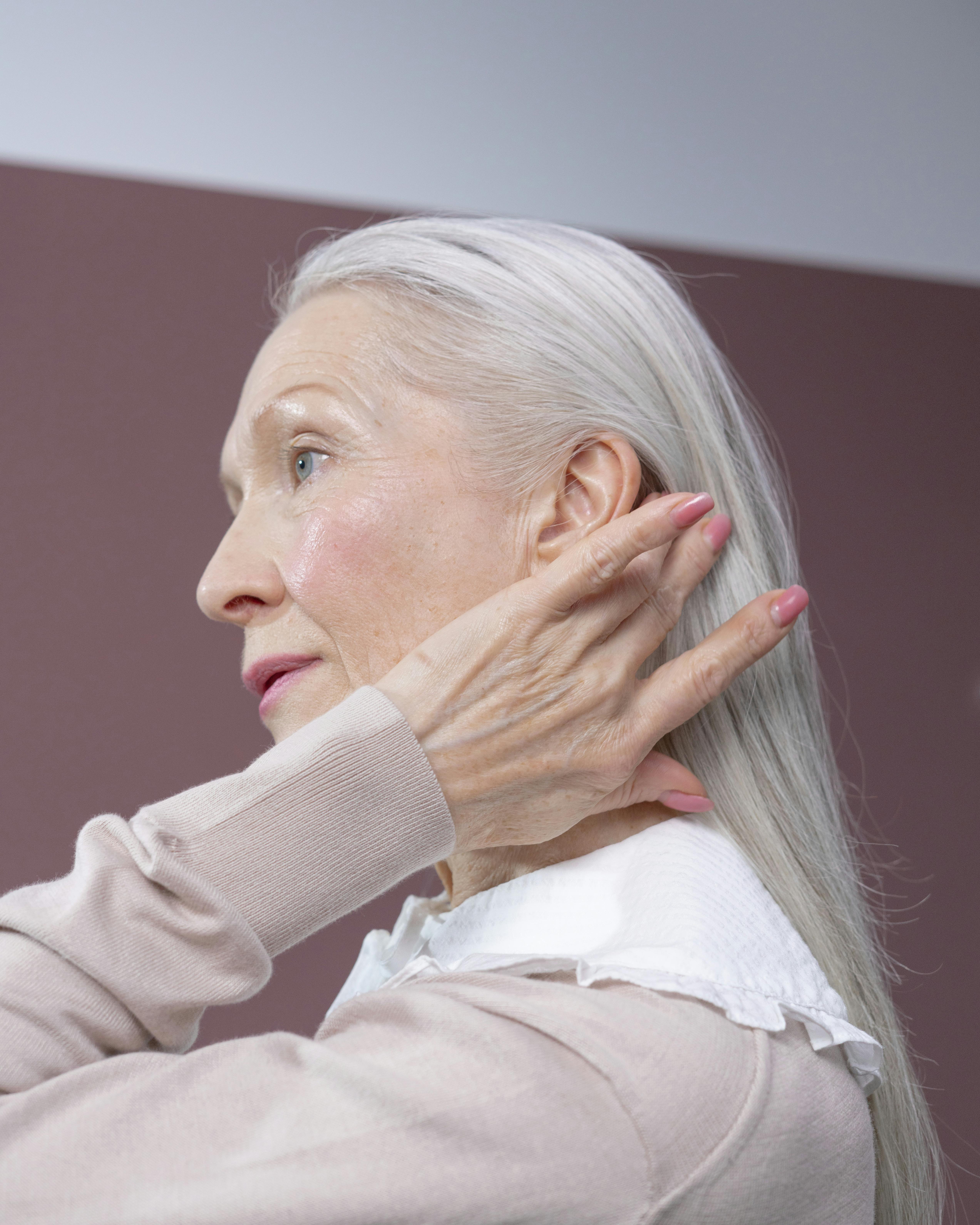 Una mujer arreglándose el pelo | Fuente: Pexels