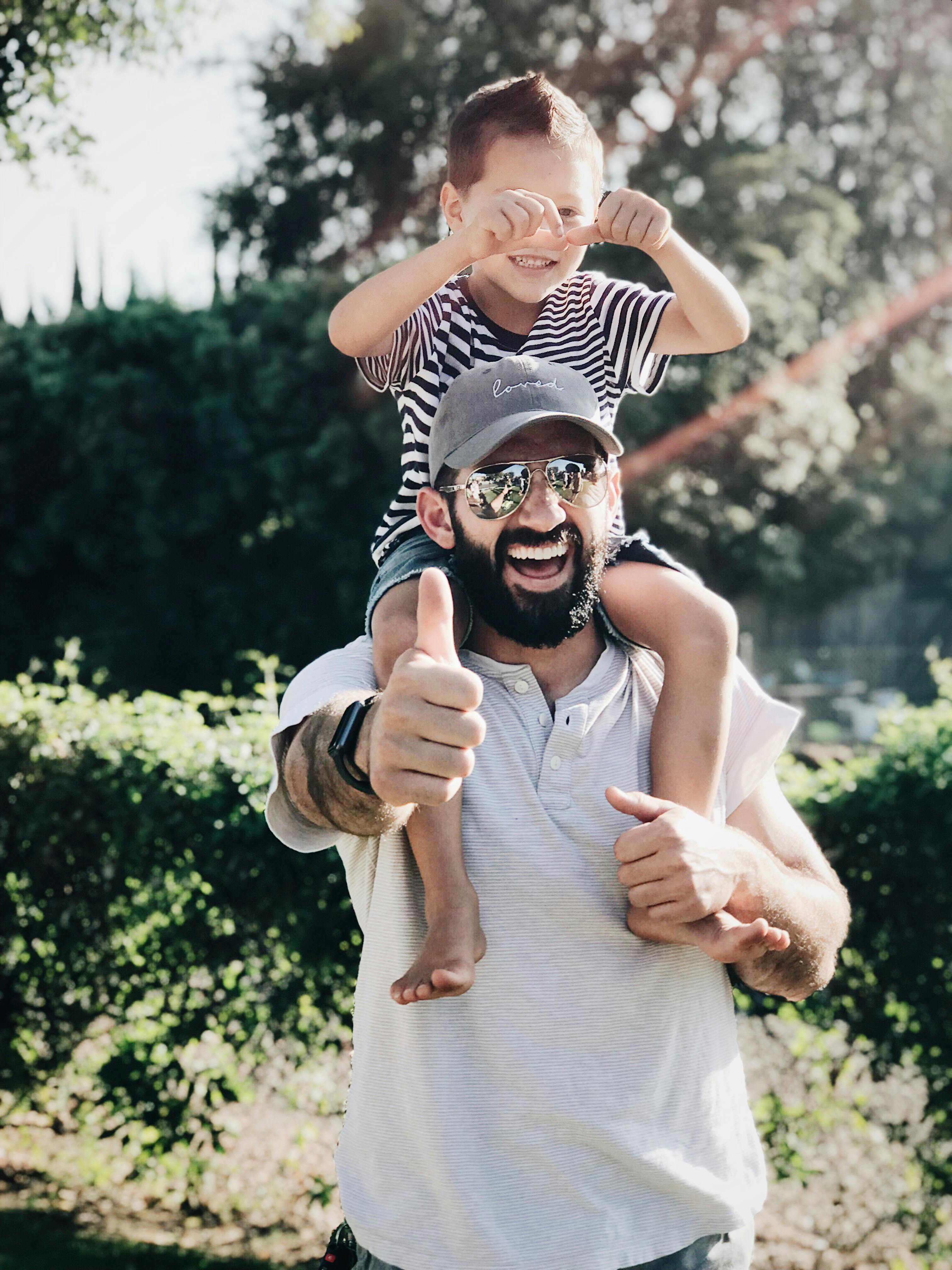 Un hombre posando con un niño sobre sus hombros | Foto: Pexels