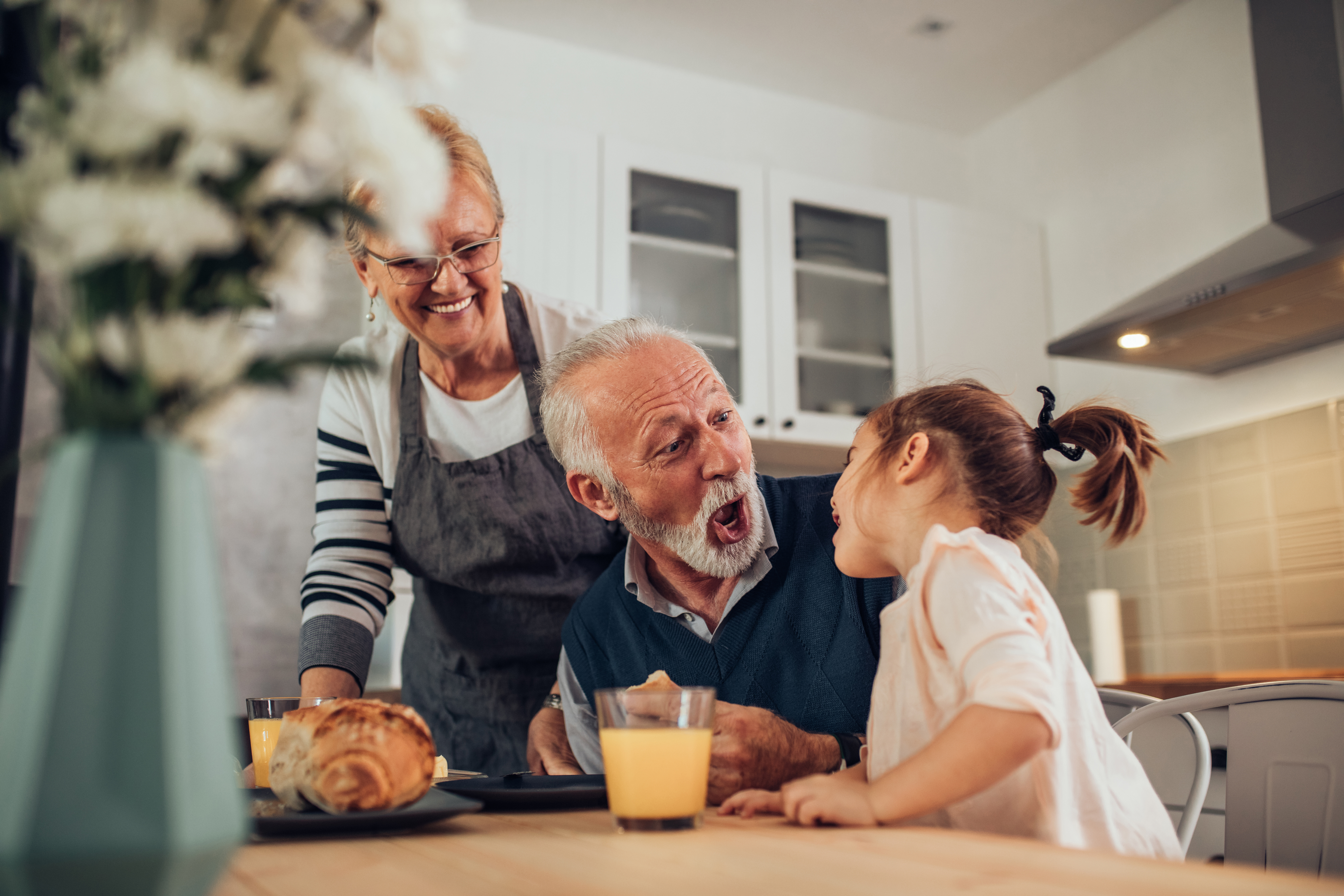Abuelos disfrutando de una comida con su nieta | Foto: Shutterstock