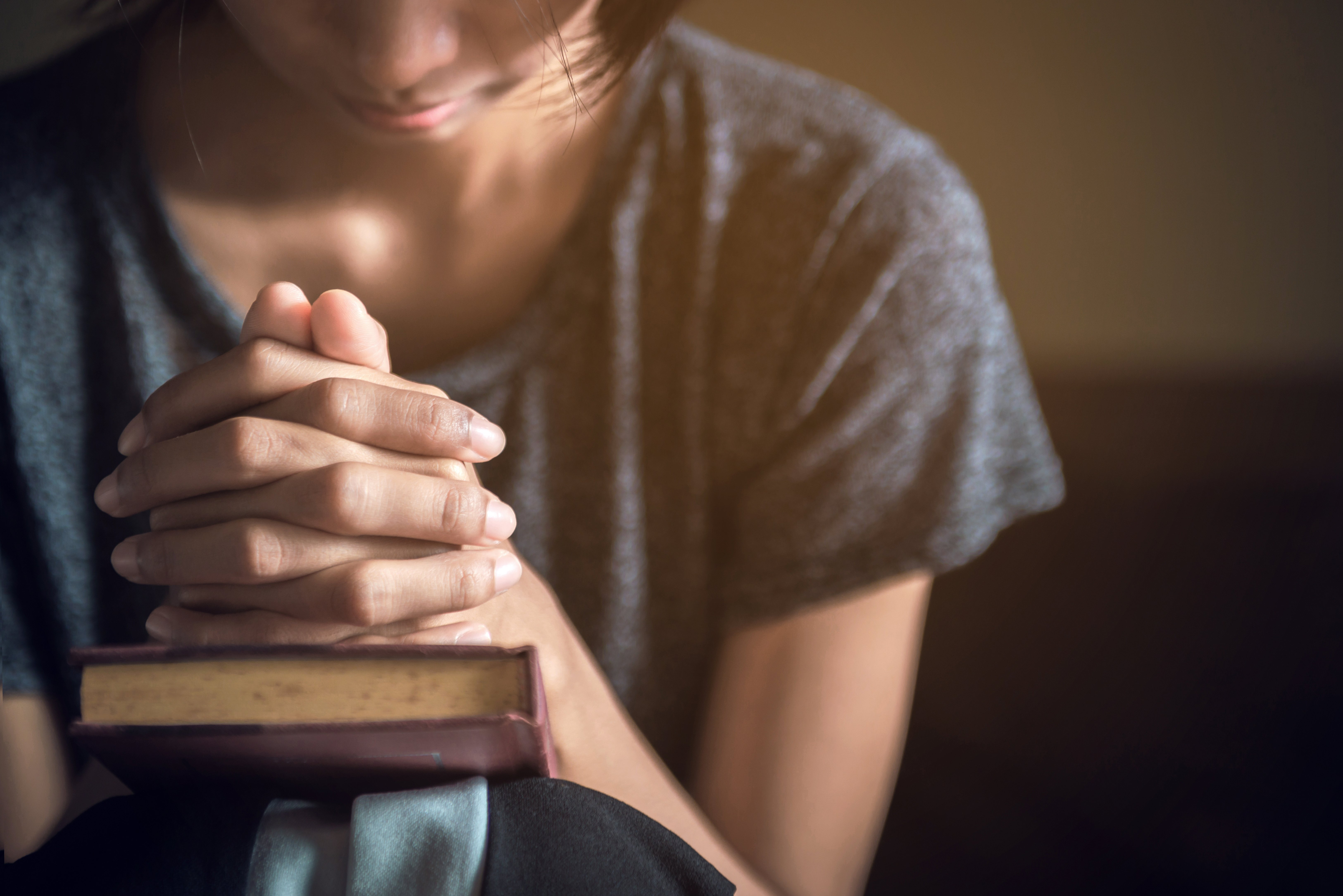 Mujer concentrada al momento de rezar. Fuente: Shutterstock