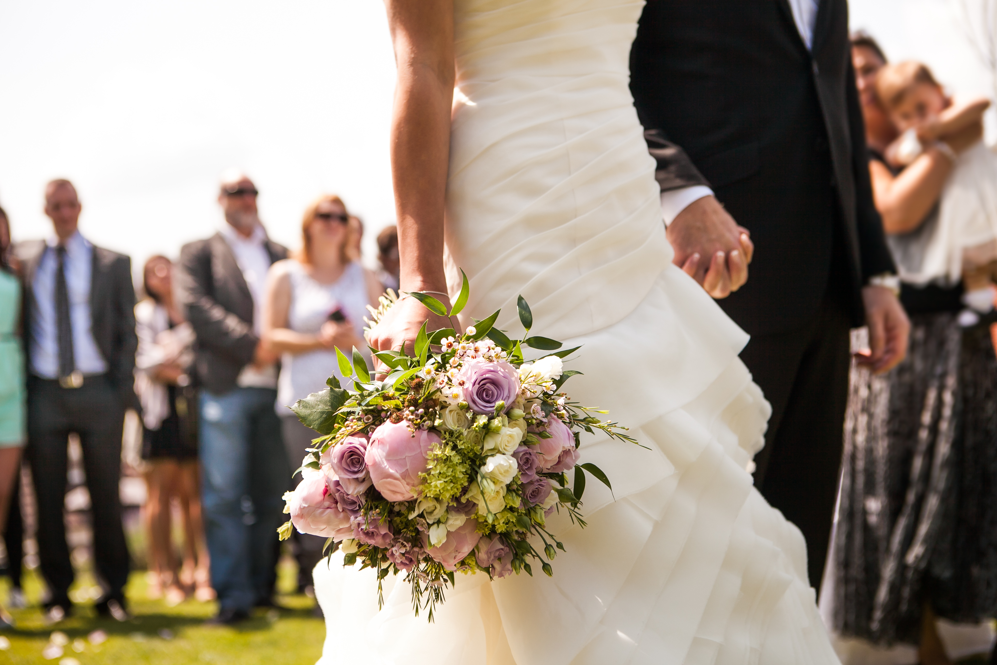 Una novia y un novio cogidos de la mano en su boda | Fuente: Shutterstock