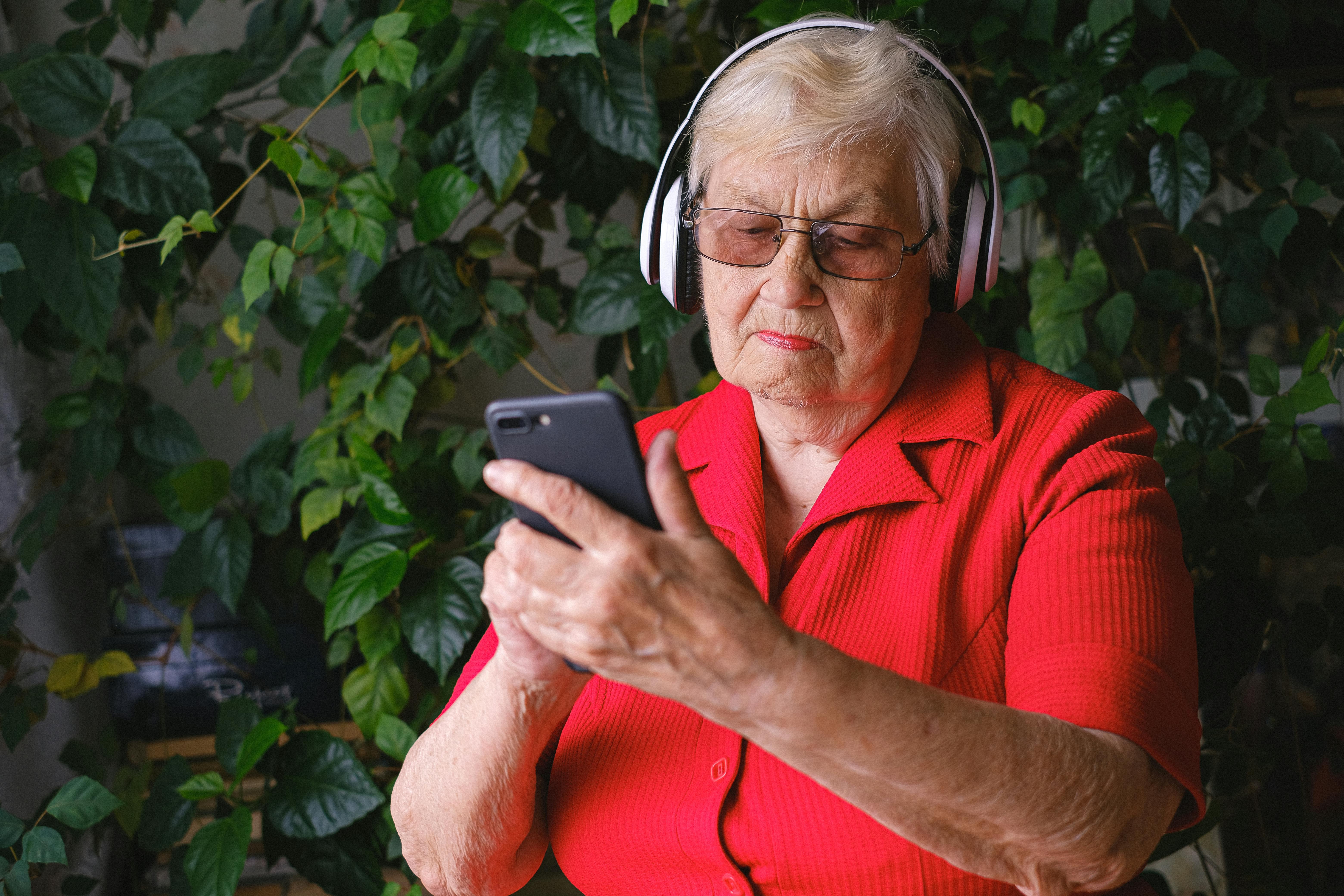 Una mujer mayor experta en tecnología manejando un teléfono móvil | Fuente: Pexels