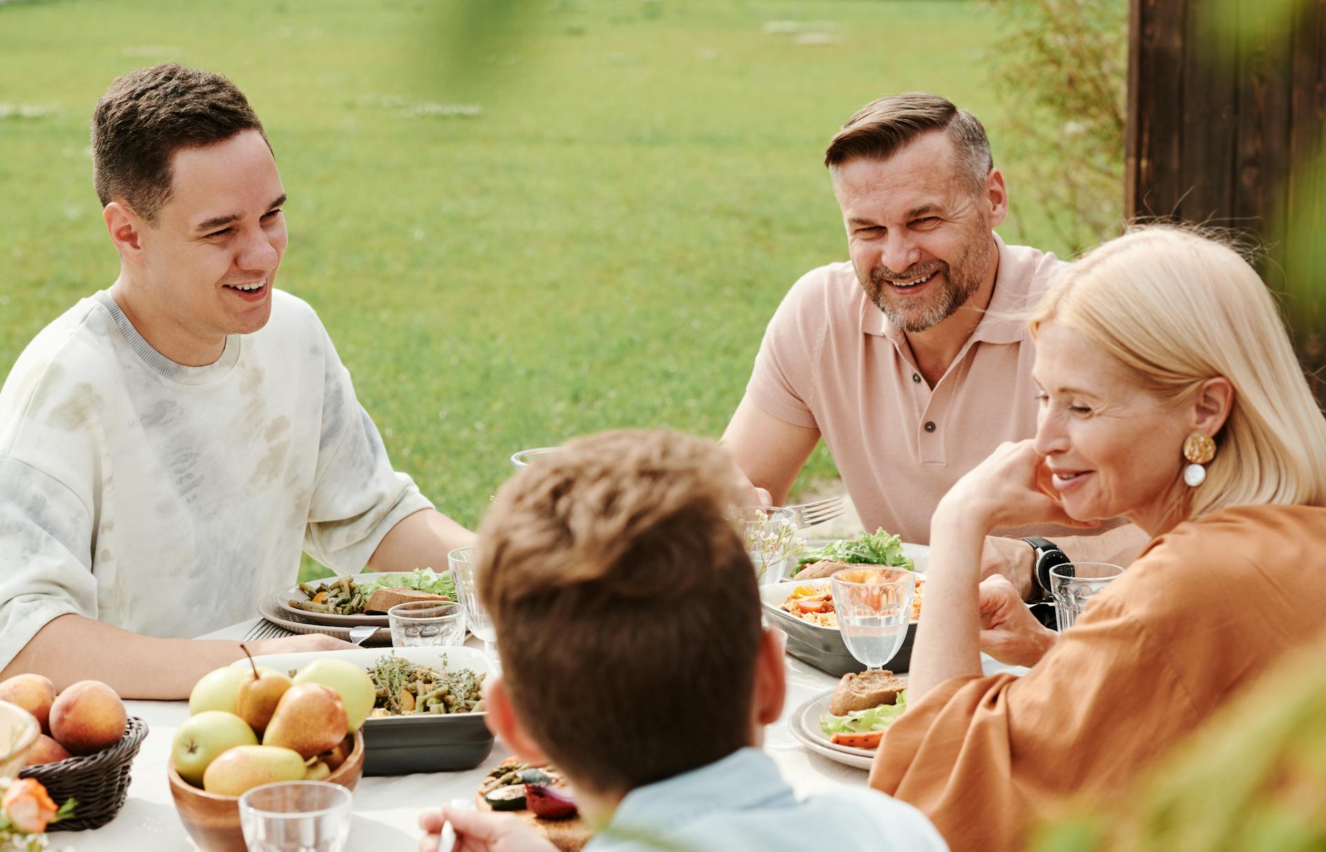Miembros de una familia cenando al aire libre | Fuente: Pexels