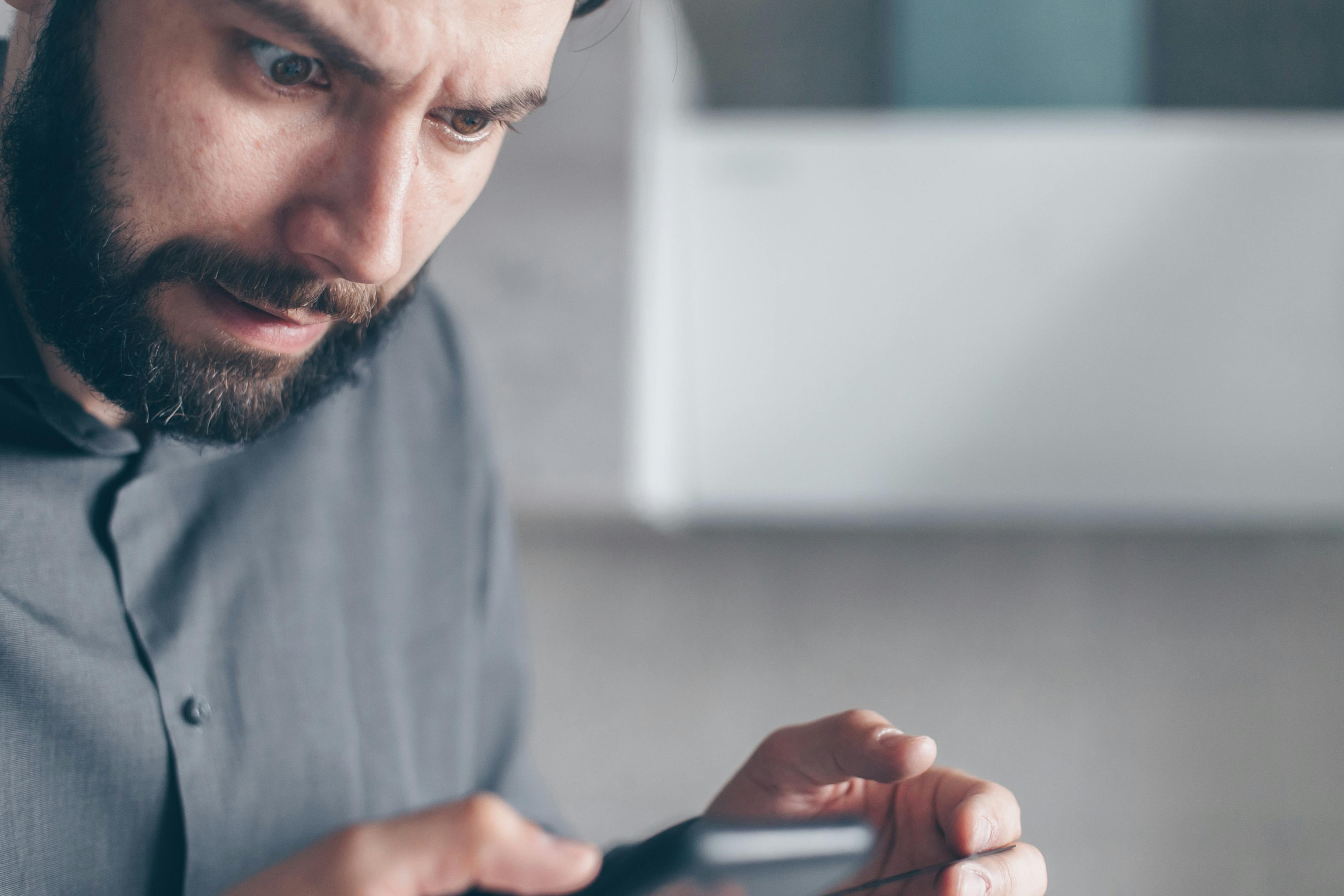 Un hombre conmocionado mirando su teléfono | Fuente: Pexels