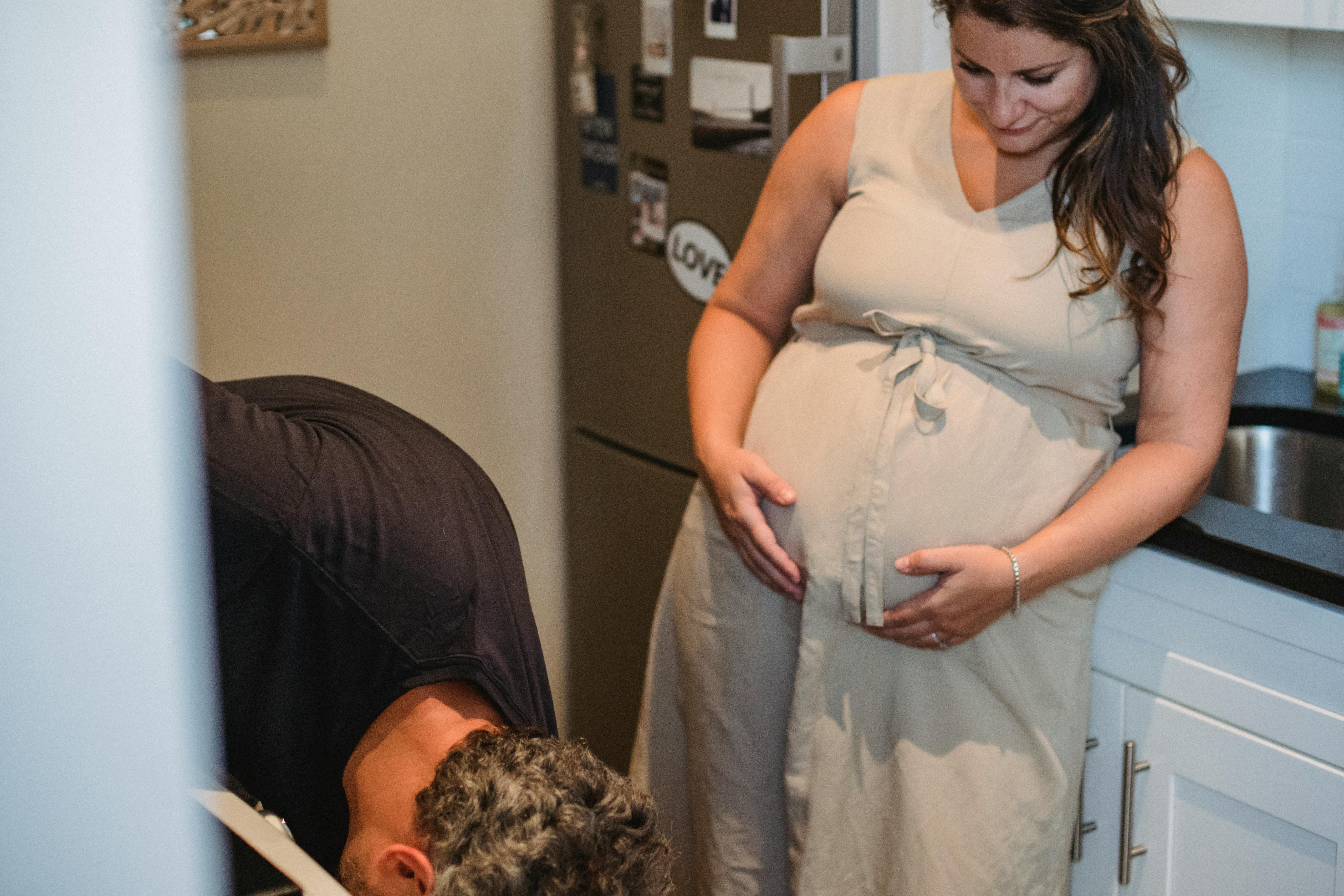 Una mujer embarazada tocándose la barriga mientras mira a su marido | Fuente: Pexels