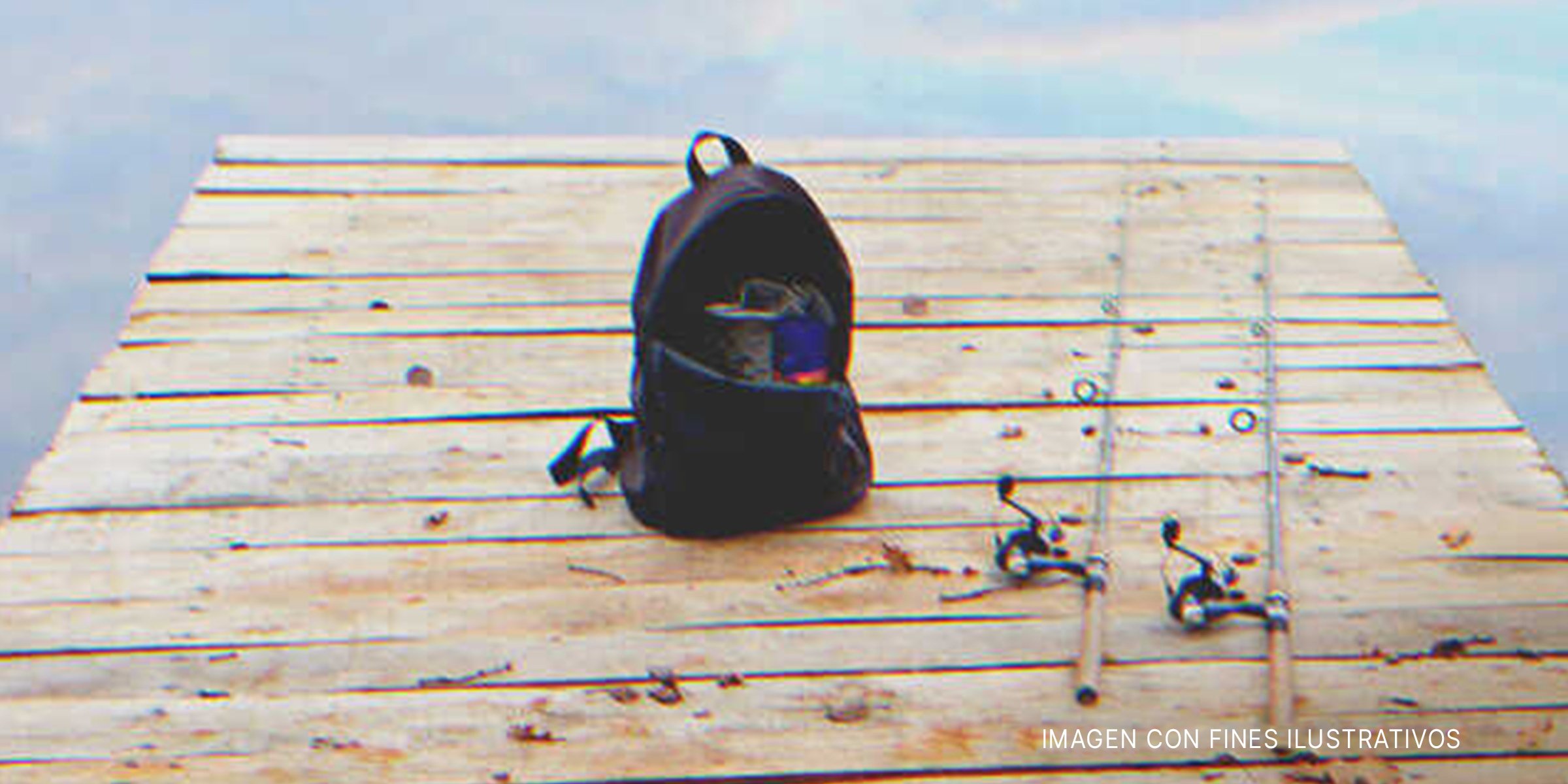 Unas cañas de pescar y una mochila sobre una plataforma de madera. | Foto: Shutterstock