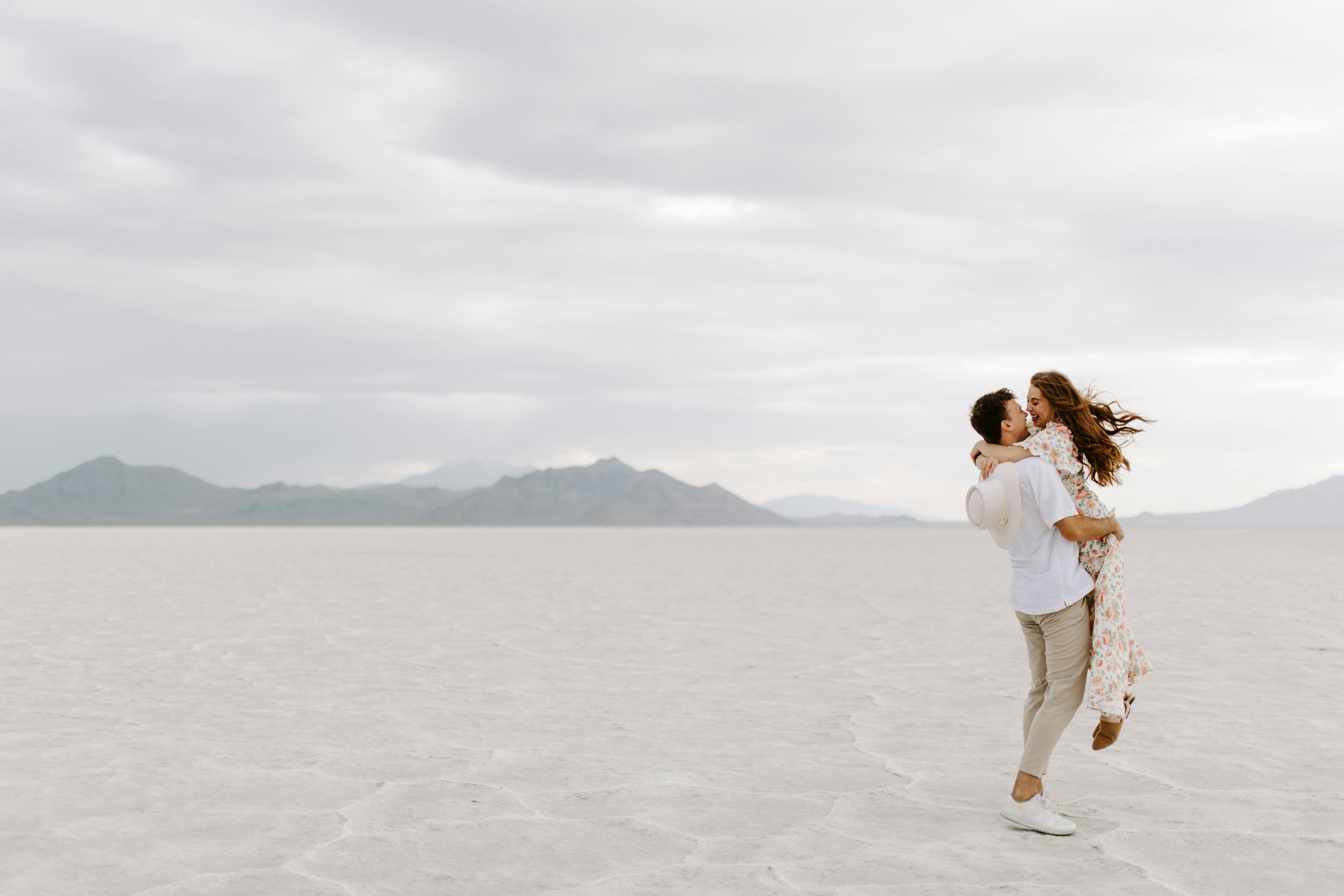 Una pareja abrazada en un desierto de arena blanca | Foto: Pexels