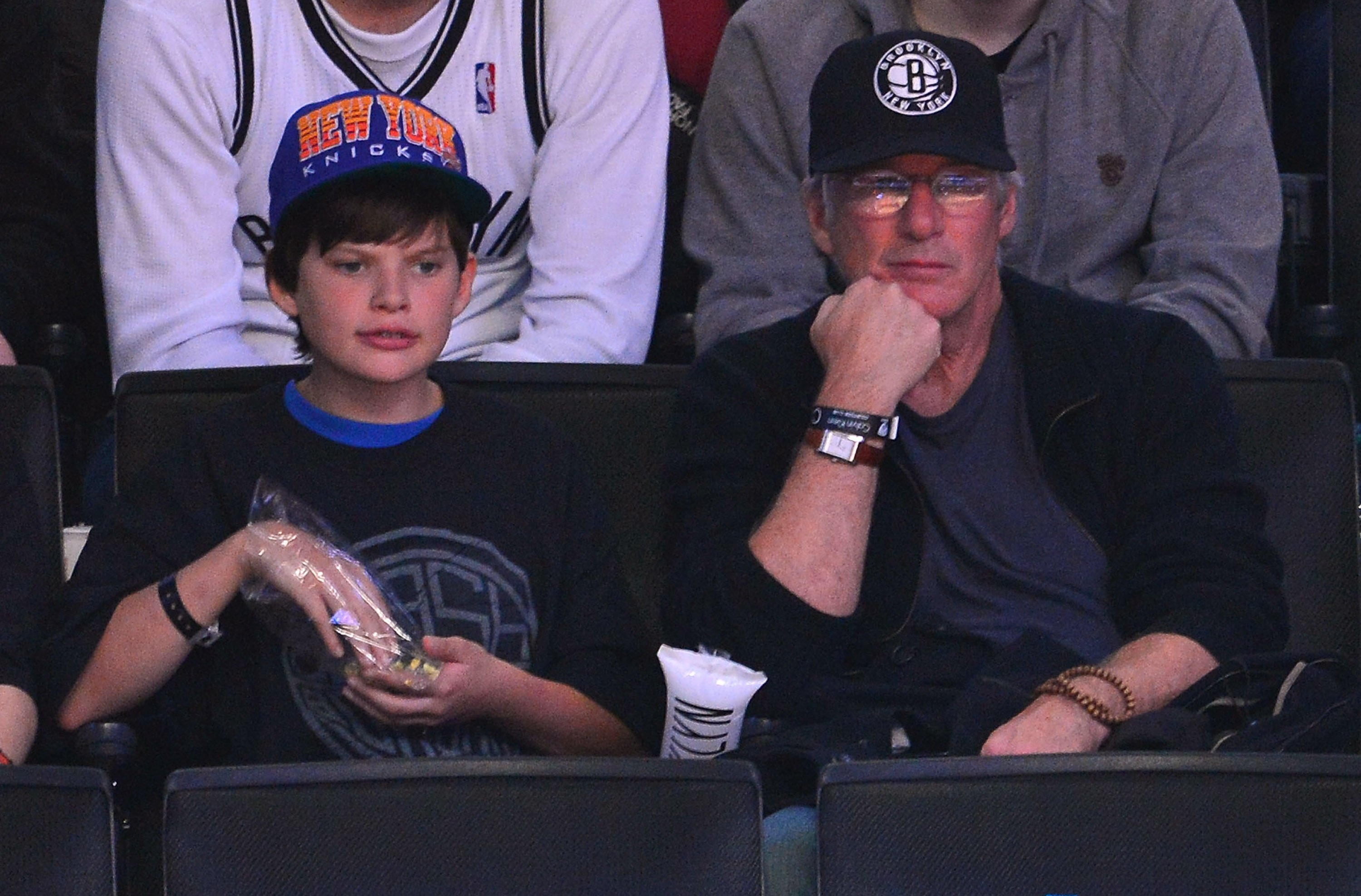 Richard Gere y su hijo Homer en el partido entre los New York Knicks y los Brooklyn Nets en 2012, en Brooklyn. | Foto: Getty Images