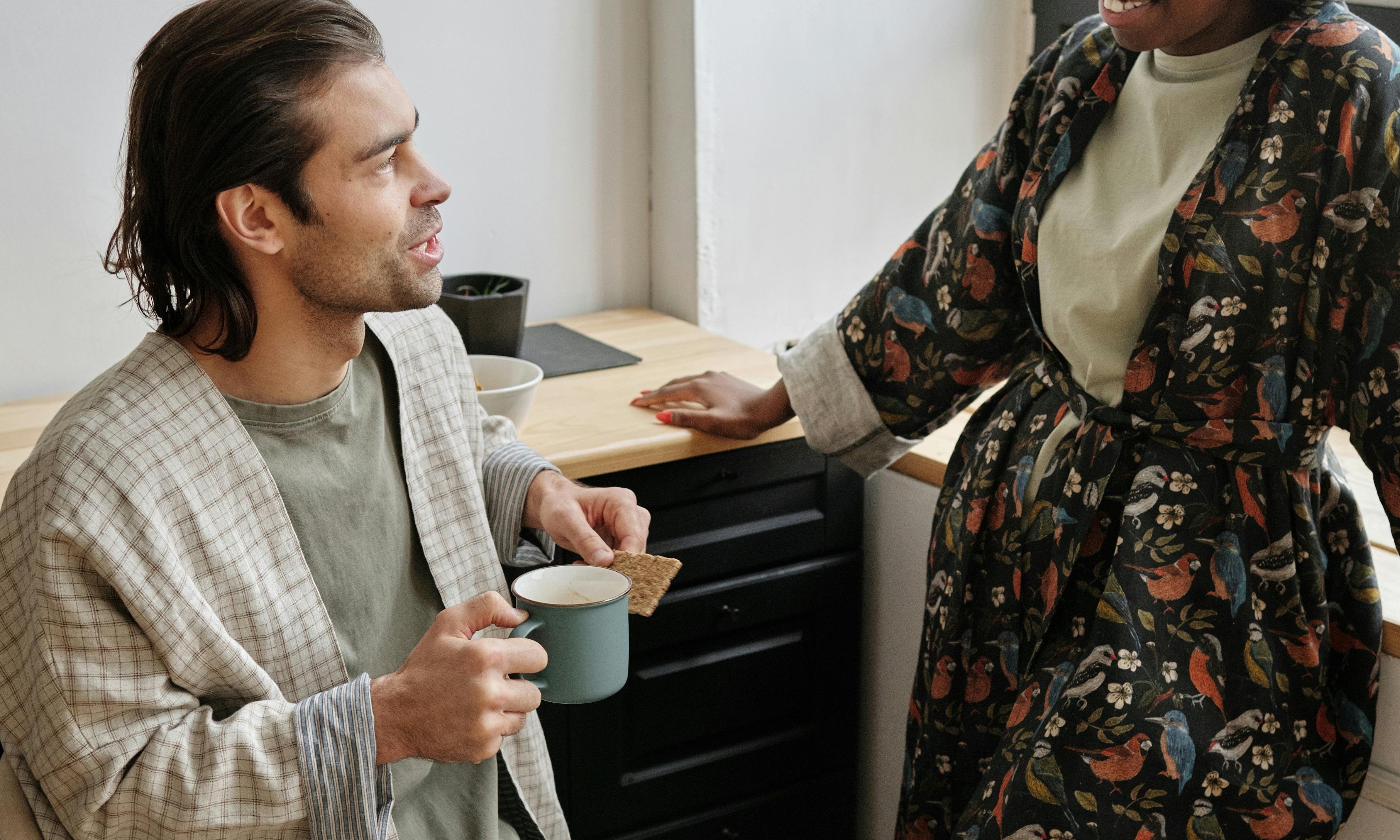 En la cocina, una mujer fuerza una sonrisa mientras su marido charla | Fuente: Pexels