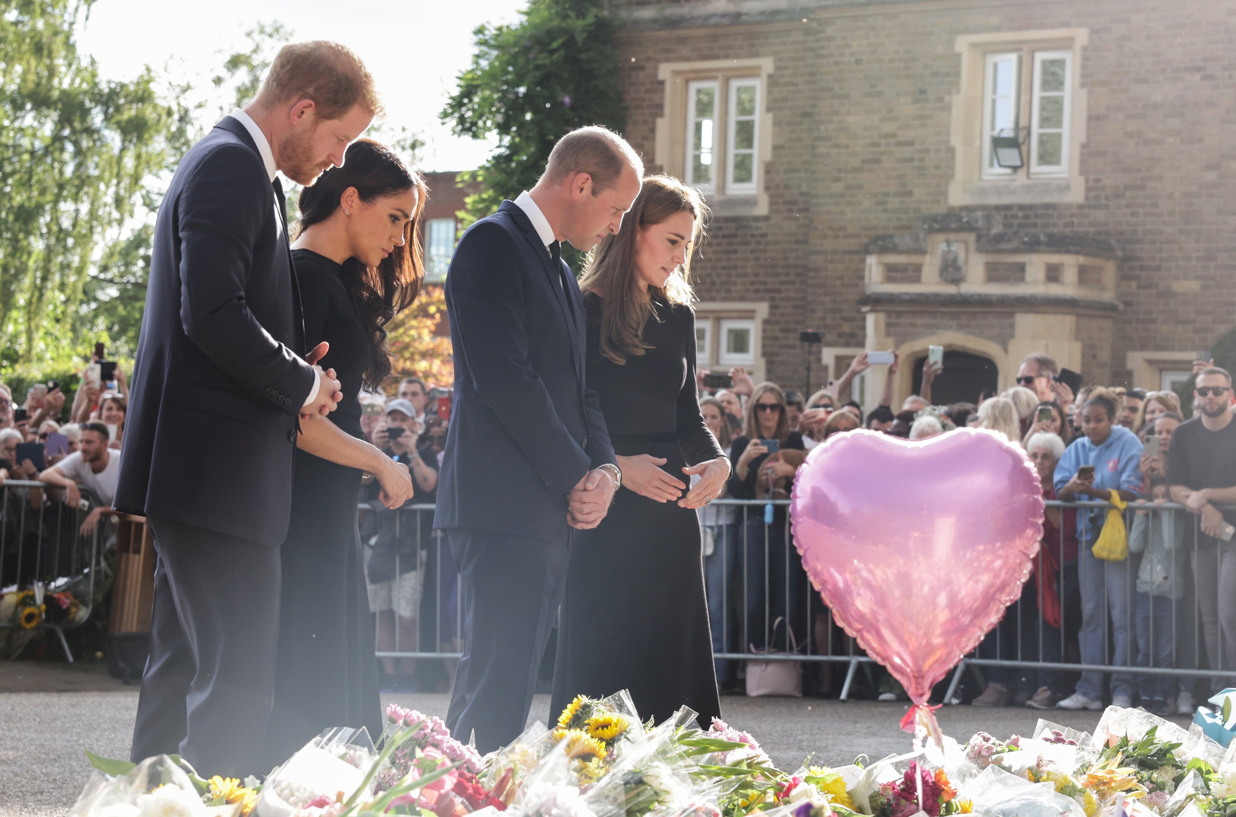 El príncipe Harry, duque de Sussex, Meghan, duquesa de Sussex, el príncipe William, príncipe de Gales y Catherine, princesa de Gales, mirando los tributos florales colocados por miembros del público en Long Walk en el castillo de Windsor, el 10 de septiembre de 2022, en Windsor, Inglaterra. | Foto: Getty Images